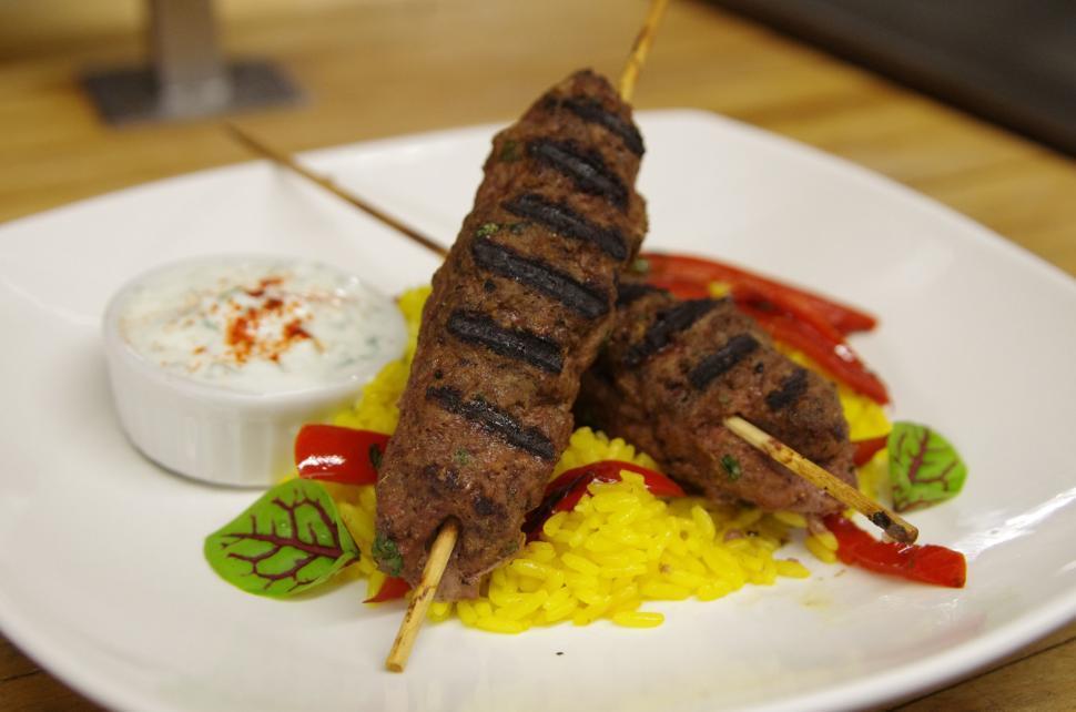 Close-up shot of Mbekbka Lamb Kebabs being served from a pot