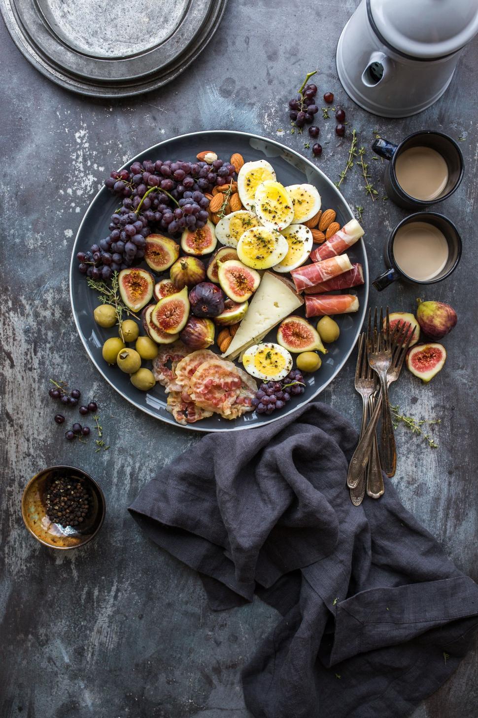 overhead shot of a person arranging berries on a cheese platter