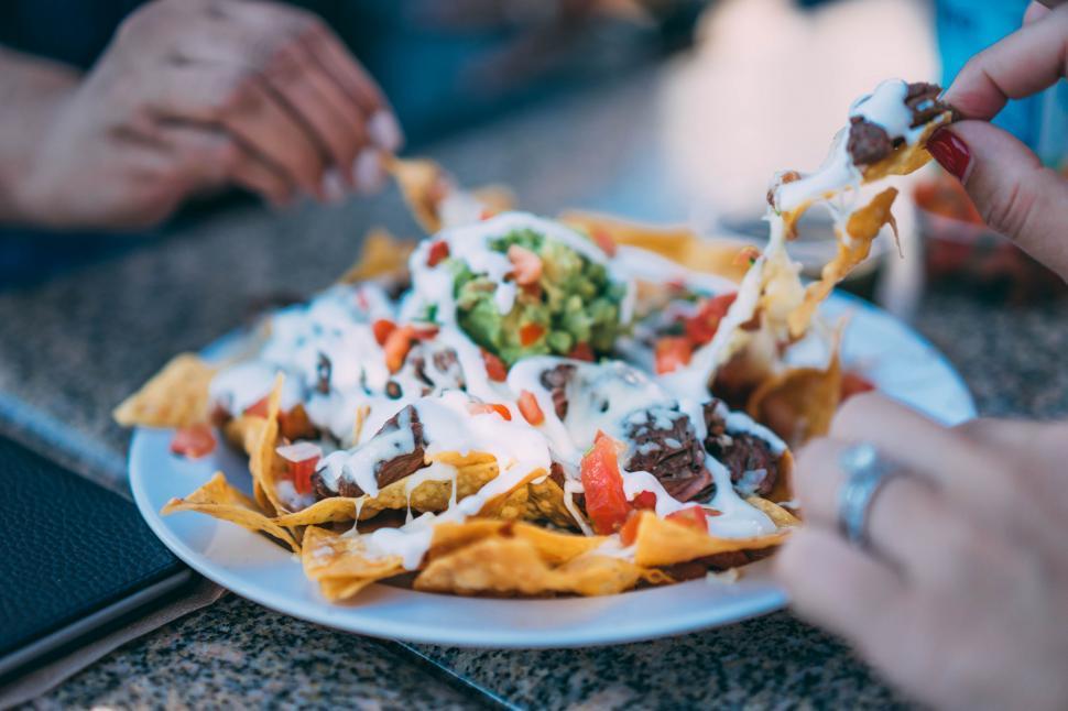 A wider shot showing a person enjoying the nachos