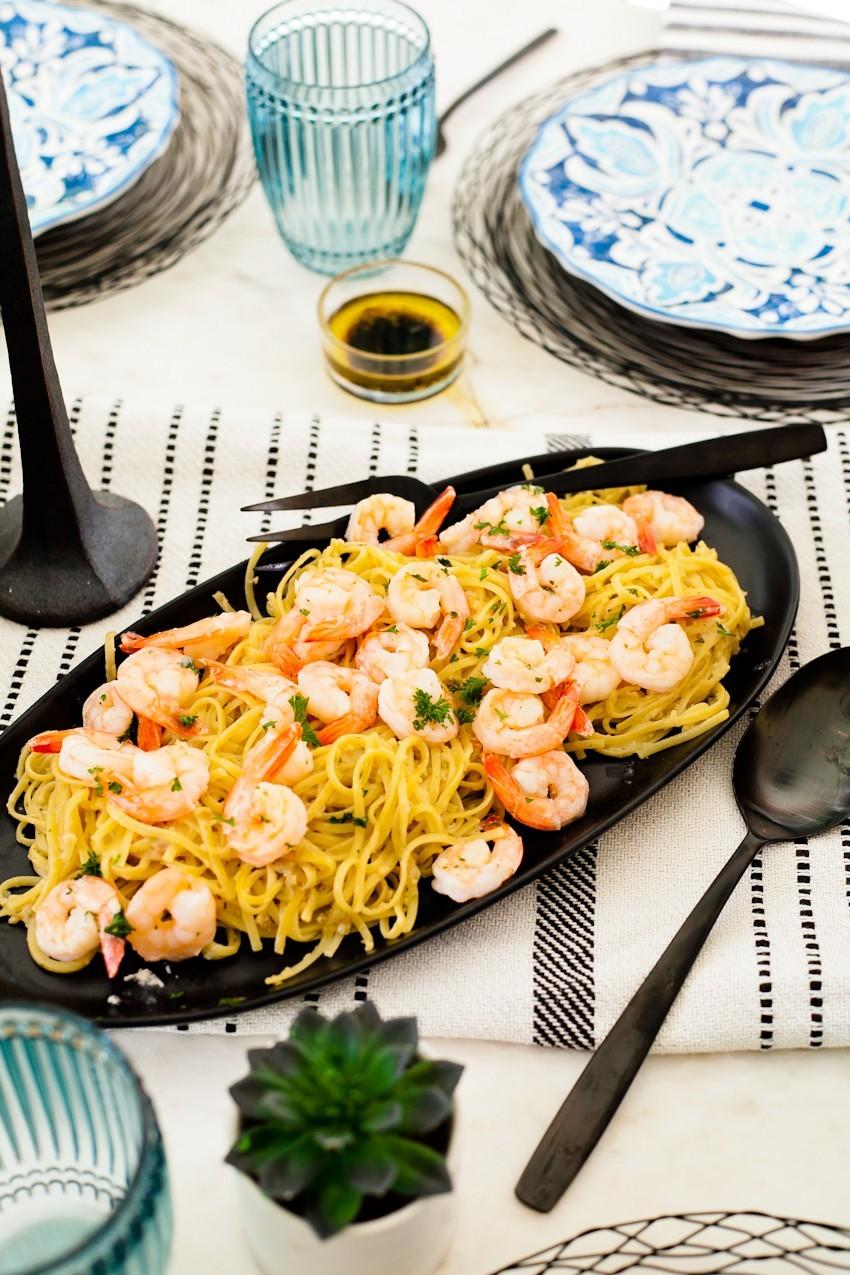 Overhead shot of a table setting with Kimchi Shrimp Scampi, drinks, and side dishes