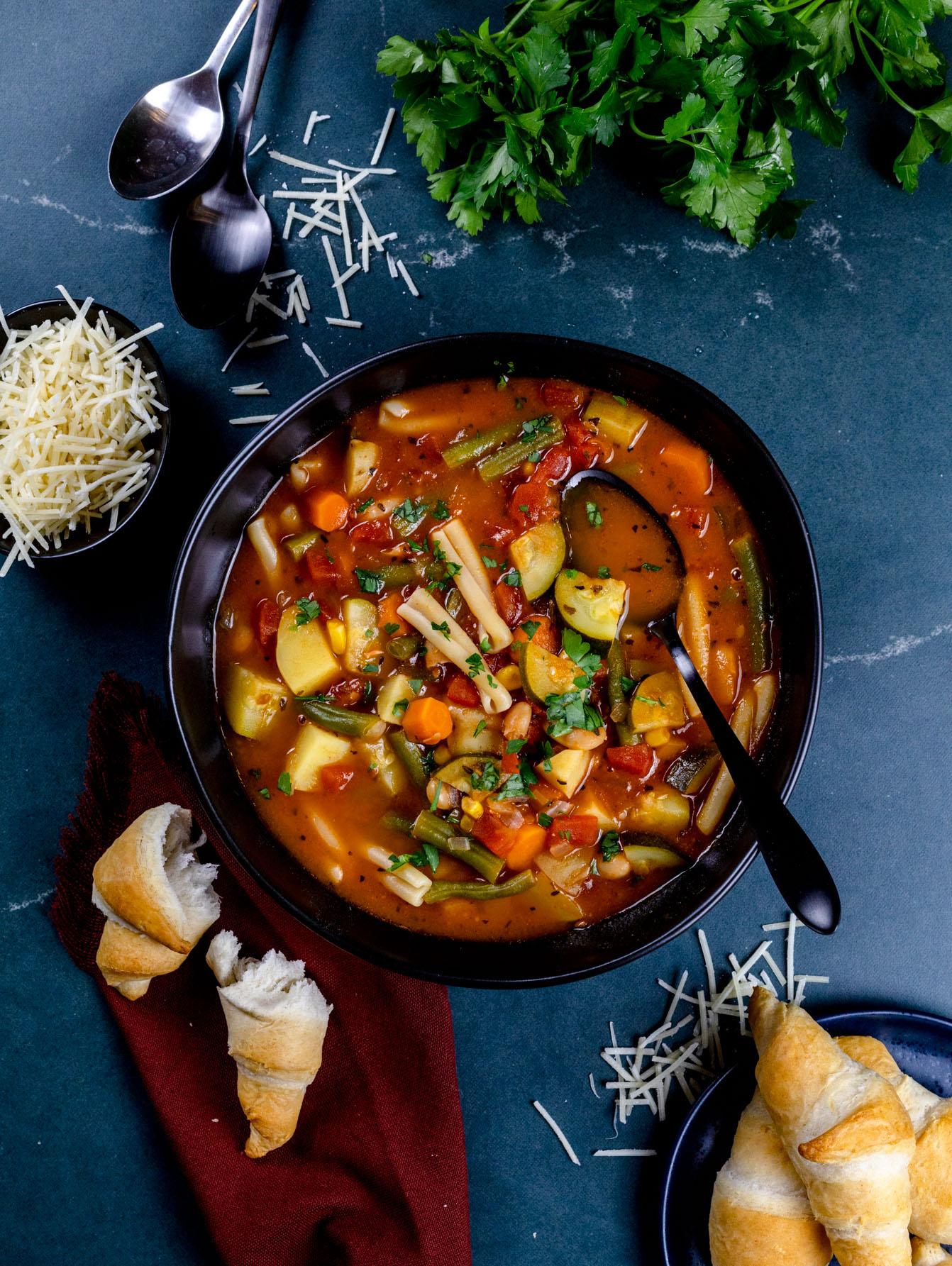 A hearty bowl of vegan minestrone soup with a sprinkle of vegan cheese