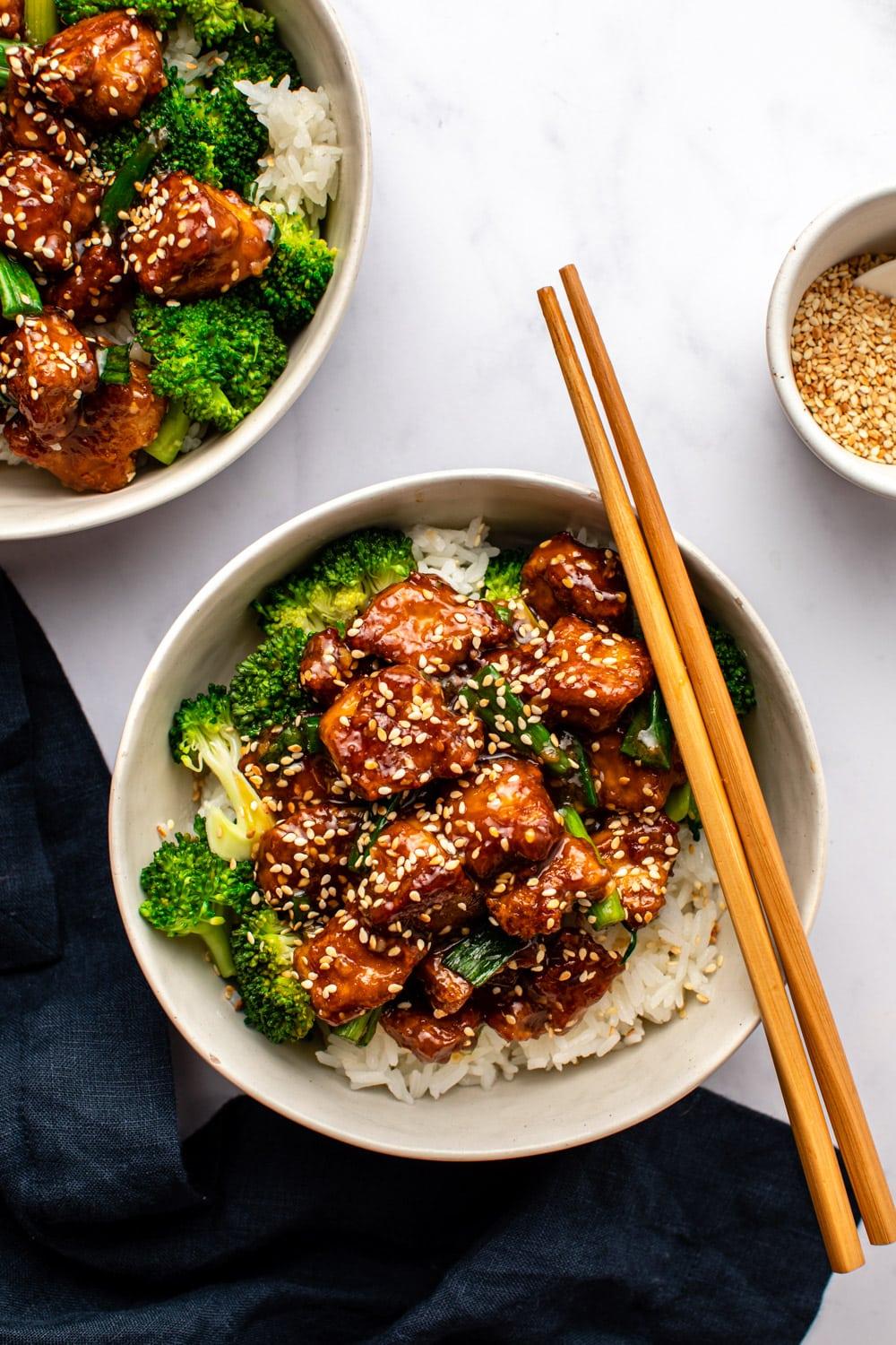 Person enjoying a bowl of Teriyaki Tofu and Brown Rice
