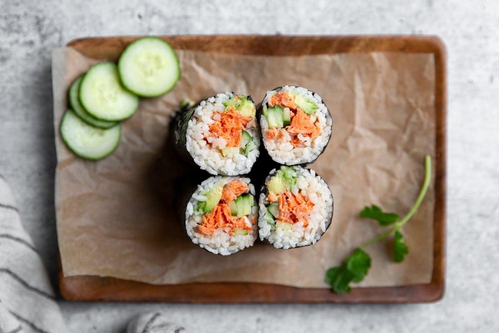 Ingredients for a Spicy Salmon Sunrise Burrito laid out on a wooden table.