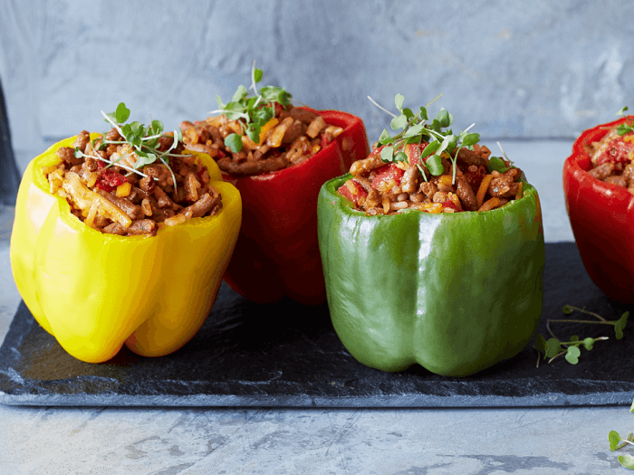 Close-up shot of vibrant stuffed peppers with a sprinkle of African spices, garnished with fresh herbs