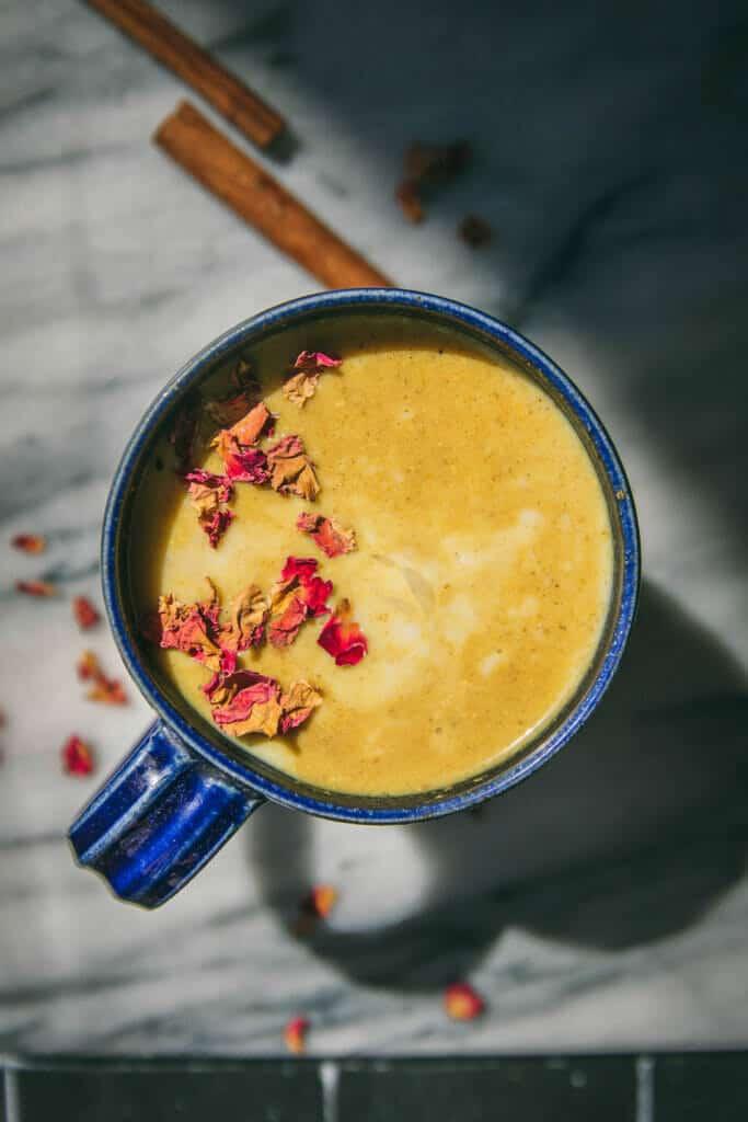 Steaming mug of golden ginger turmeric drink, condensation on the mug