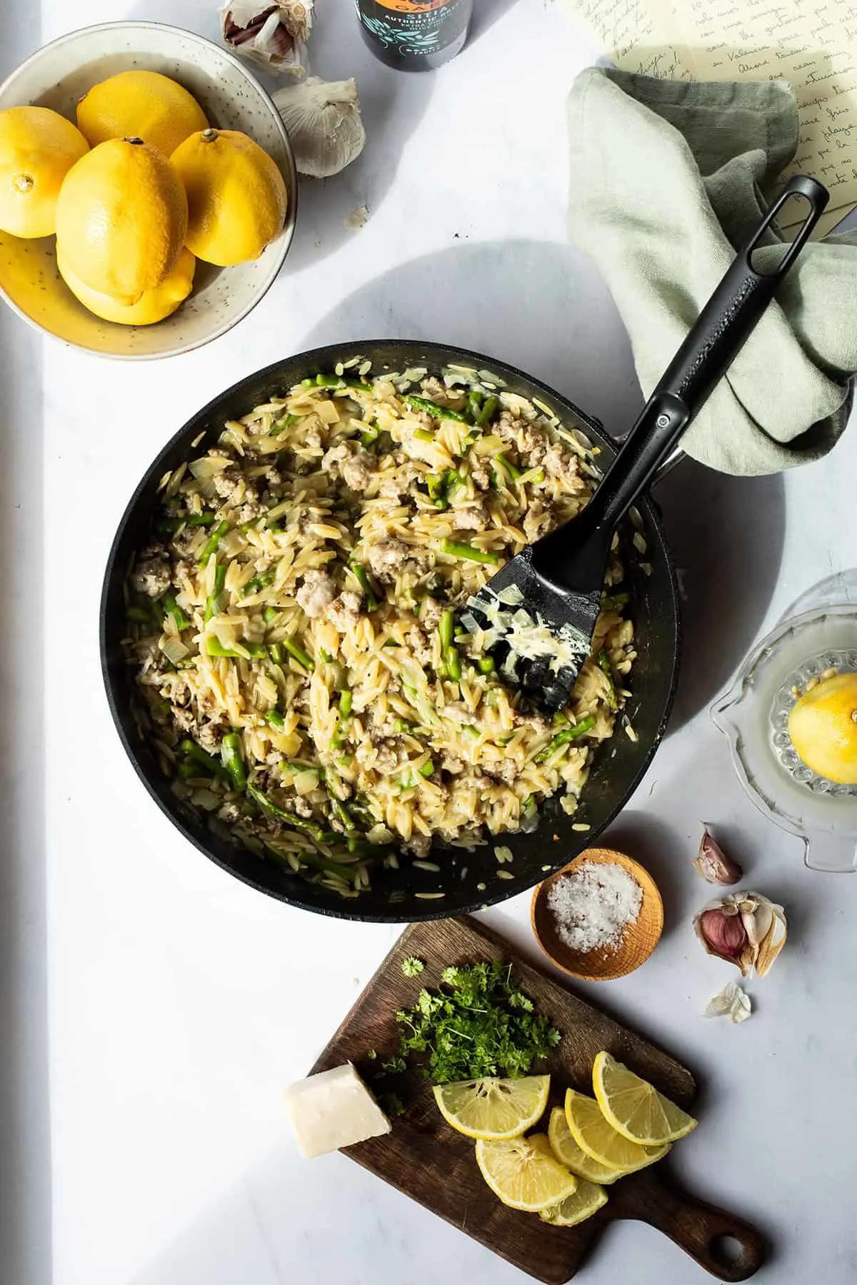 A person enjoying a plate of One-Pan Lemon Parmesan Zoodles and Sausage