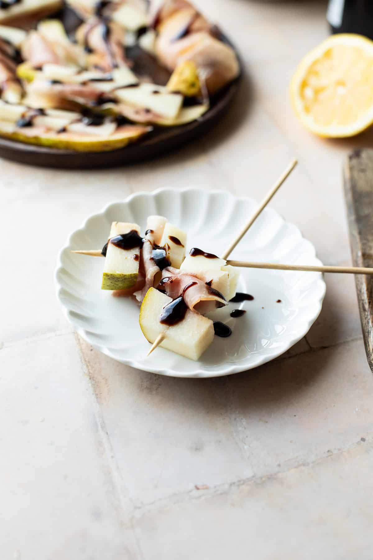 A platter of sliced smoked Manchego with honey and fresh herbs
