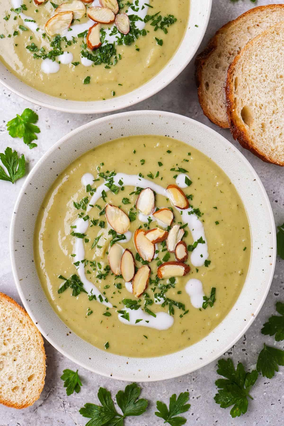 bowl of creamy vegan broccoli soup with toasted almonds and parsley