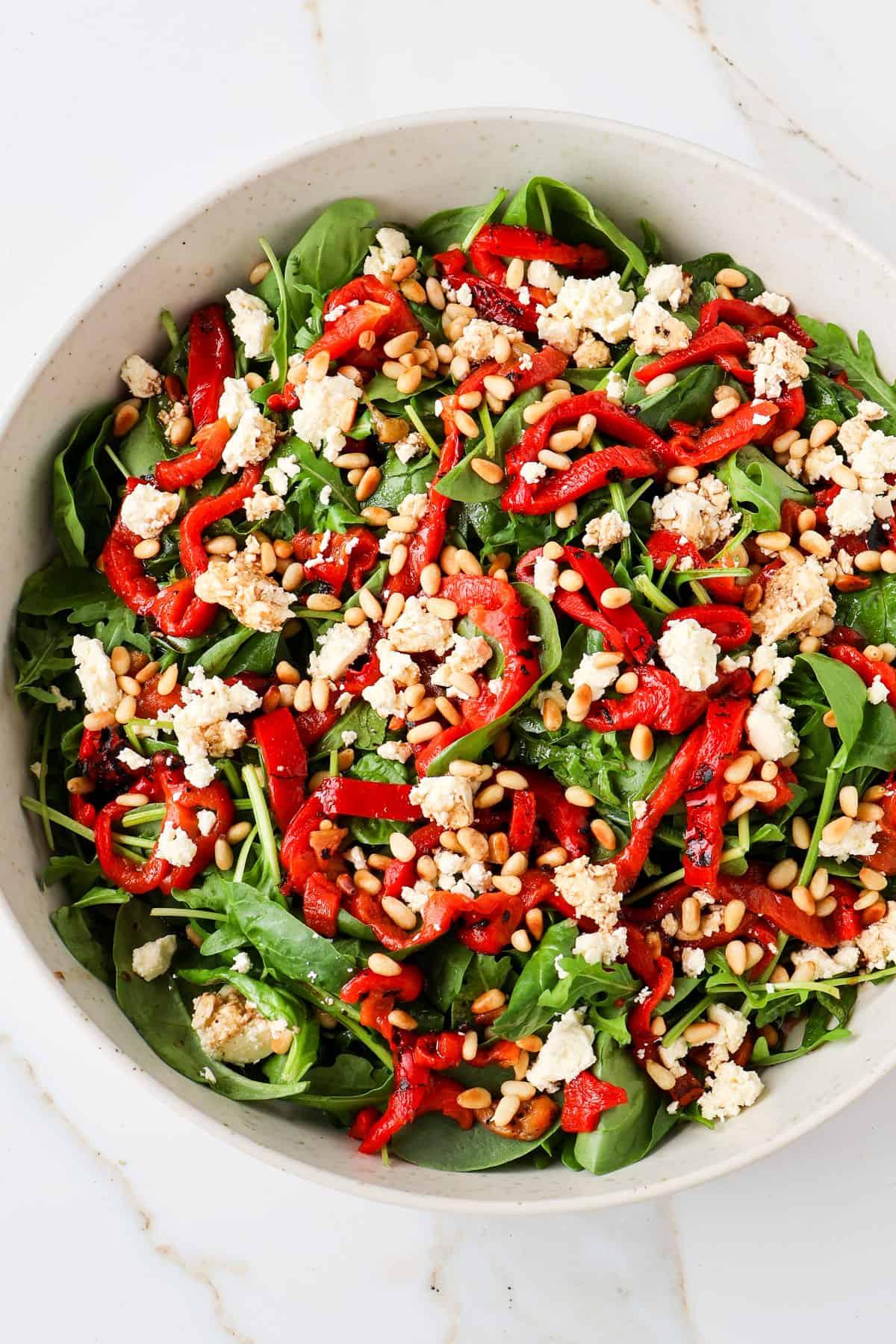 Close up shot of a vibrant arugula salad with roasted vegetables