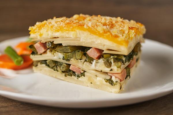 Ingredients for callaloo lasagna laid out on a kitchen counter