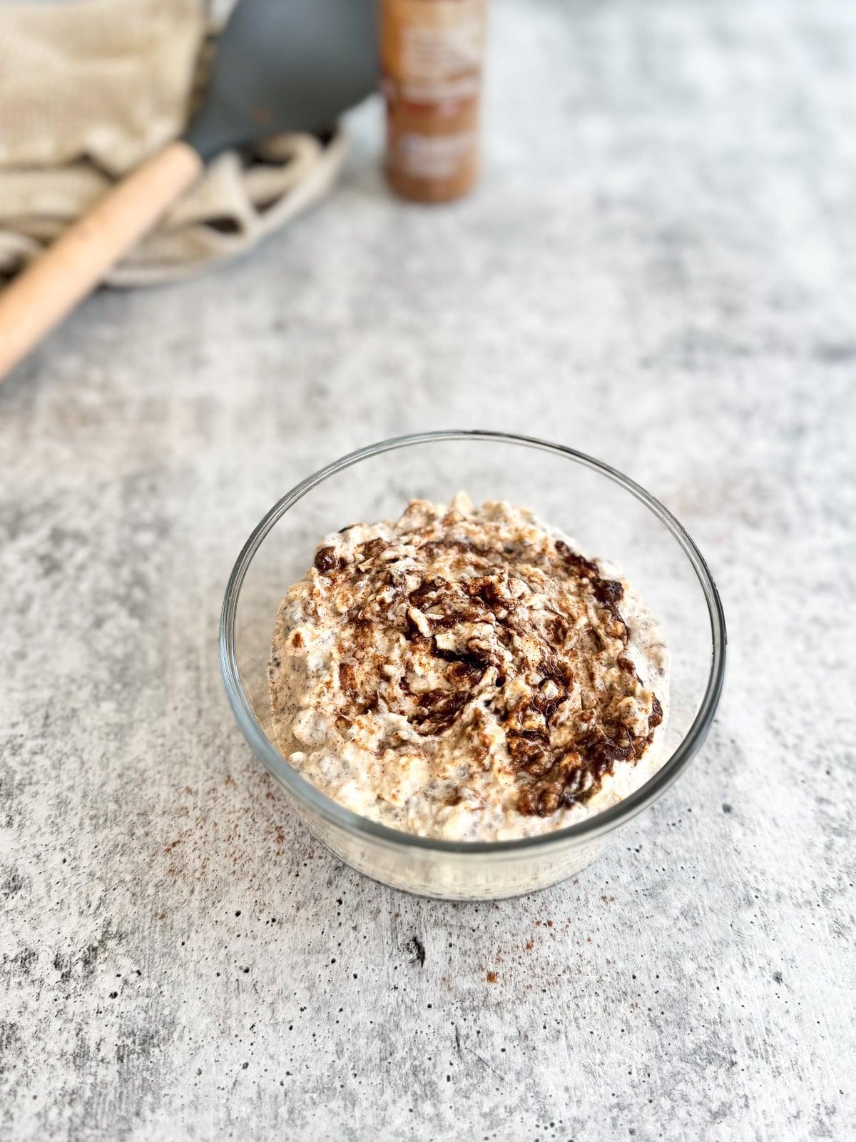 A close-up shot of a spoon scooping up a creamy texture of Cinnamon Roll Overnight Oats