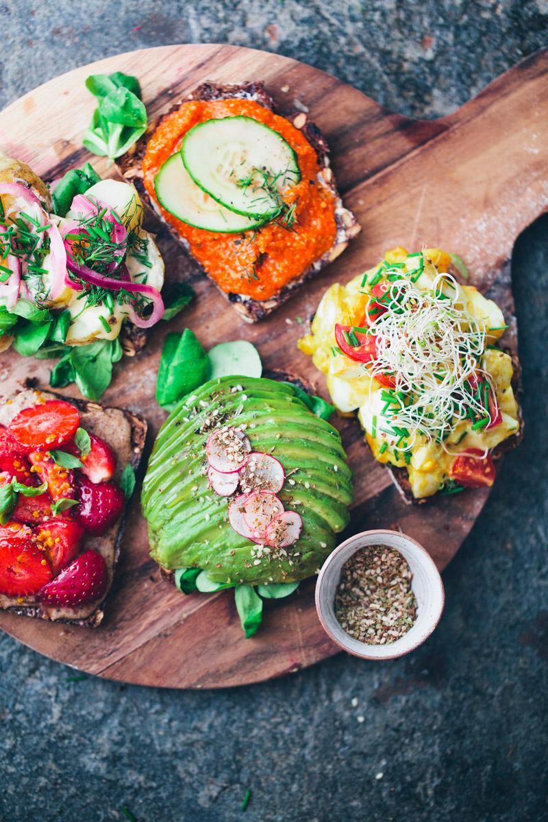 A table set for brunch with several open-faced sandwiches