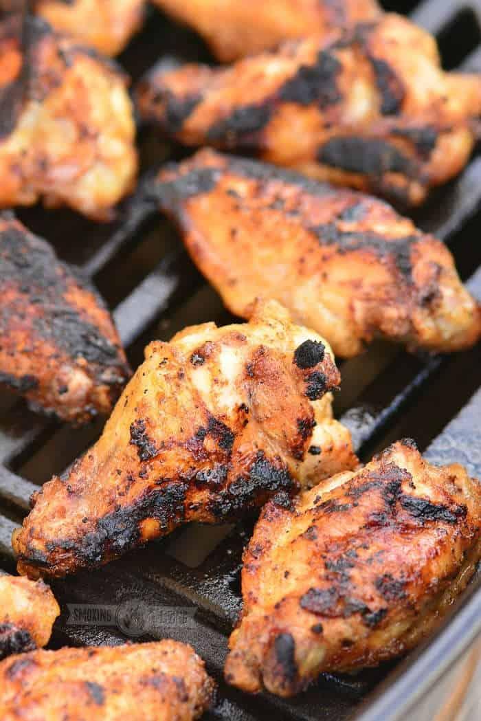 Close-up shot of delicious, grilled Atlanta-style chicken wings on a grill, with a slightly charred and crispy exterior.