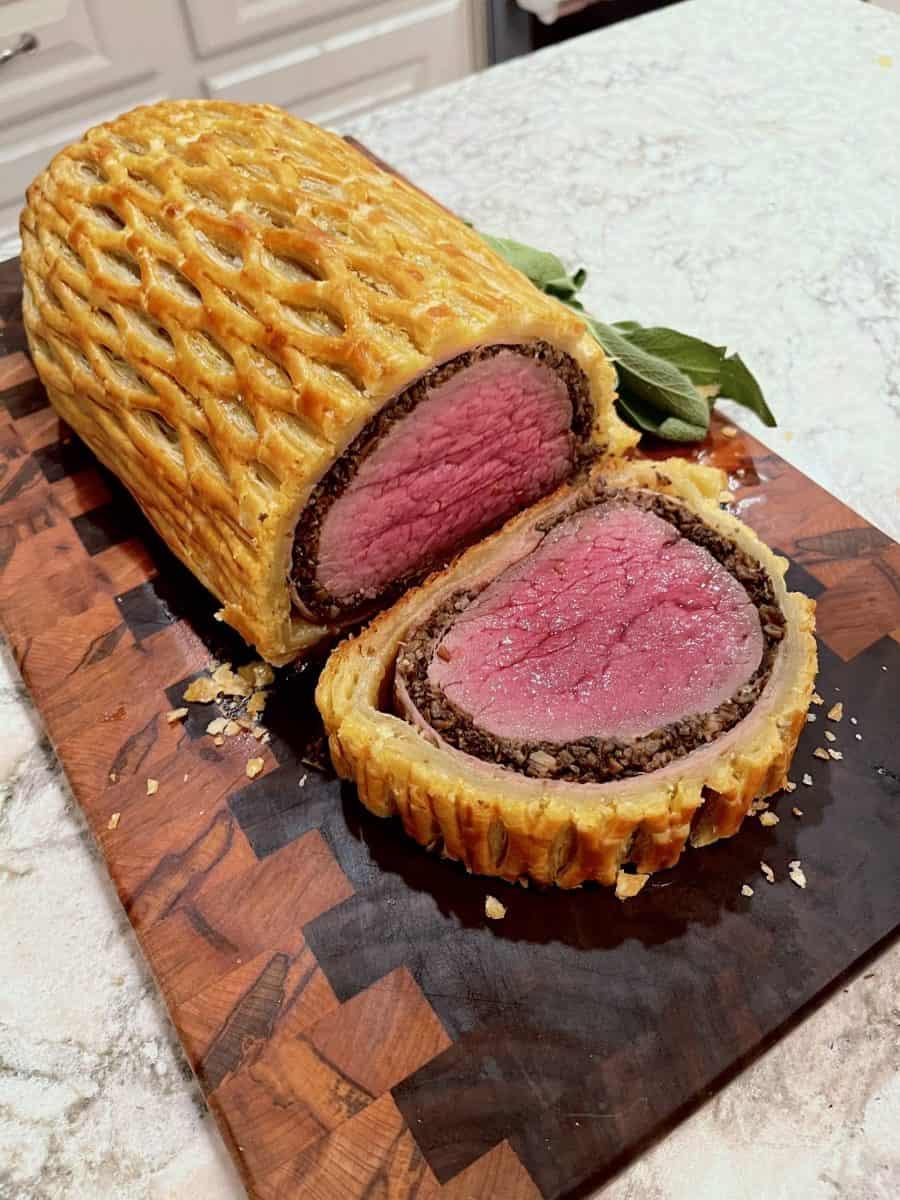 Beef Wellington sliced and served, showing the layers of pastry and meat