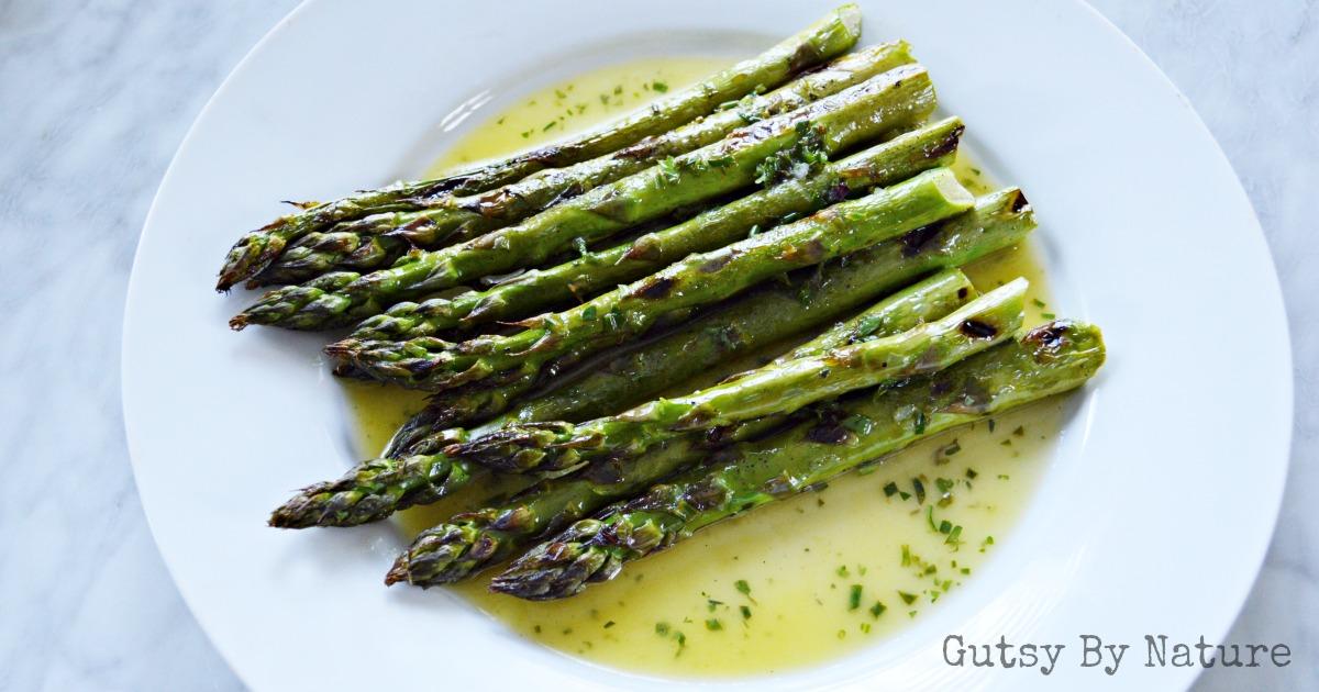 close up of grilled asparagus drizzled with lemon-herb sauce