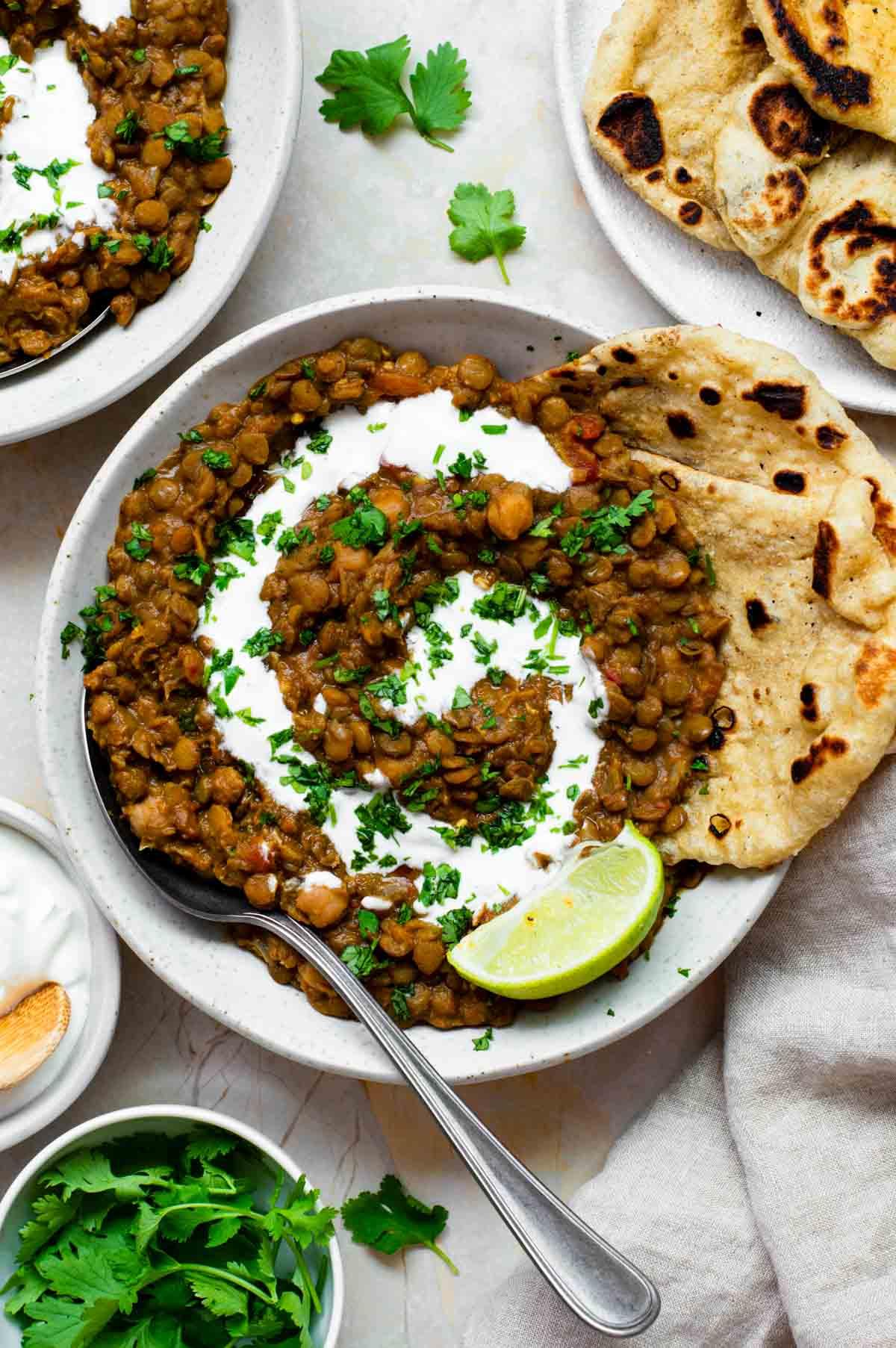 Lentil roti served with a side of vegetable curry and yogurt
