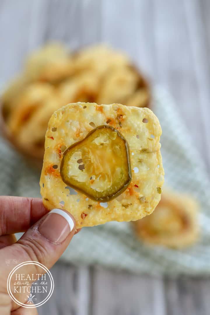 overhead view of a hand reaching for a jalapeno keto cracker