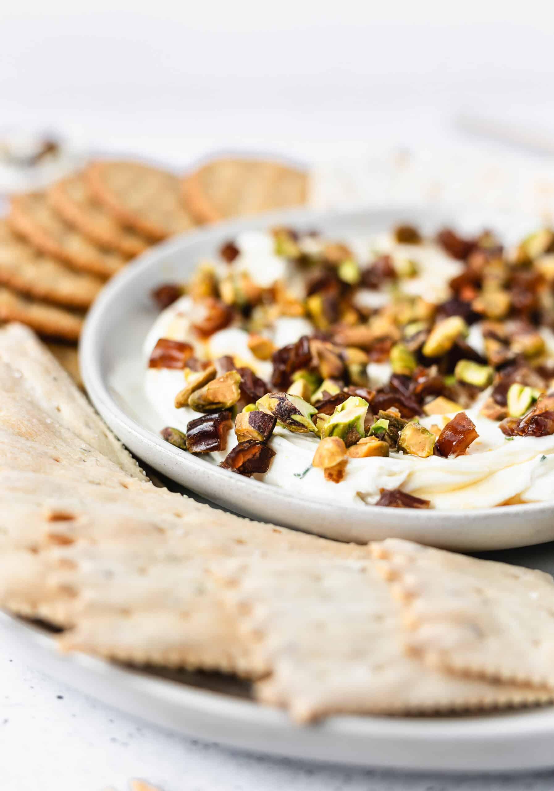 Close-up of creamy goat cheese and honey dip served with flatbread and walnuts