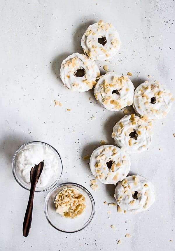 Close-up shot of a single coconut cream pie donut, generously topped with coconut flakes