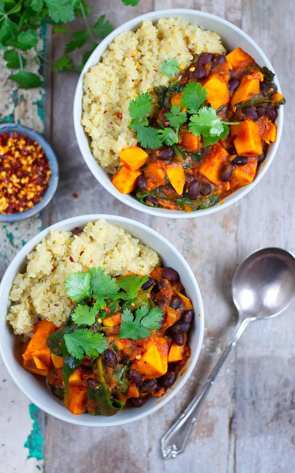 A person enjoying a bowl of roasted sweet potato and black bean stew