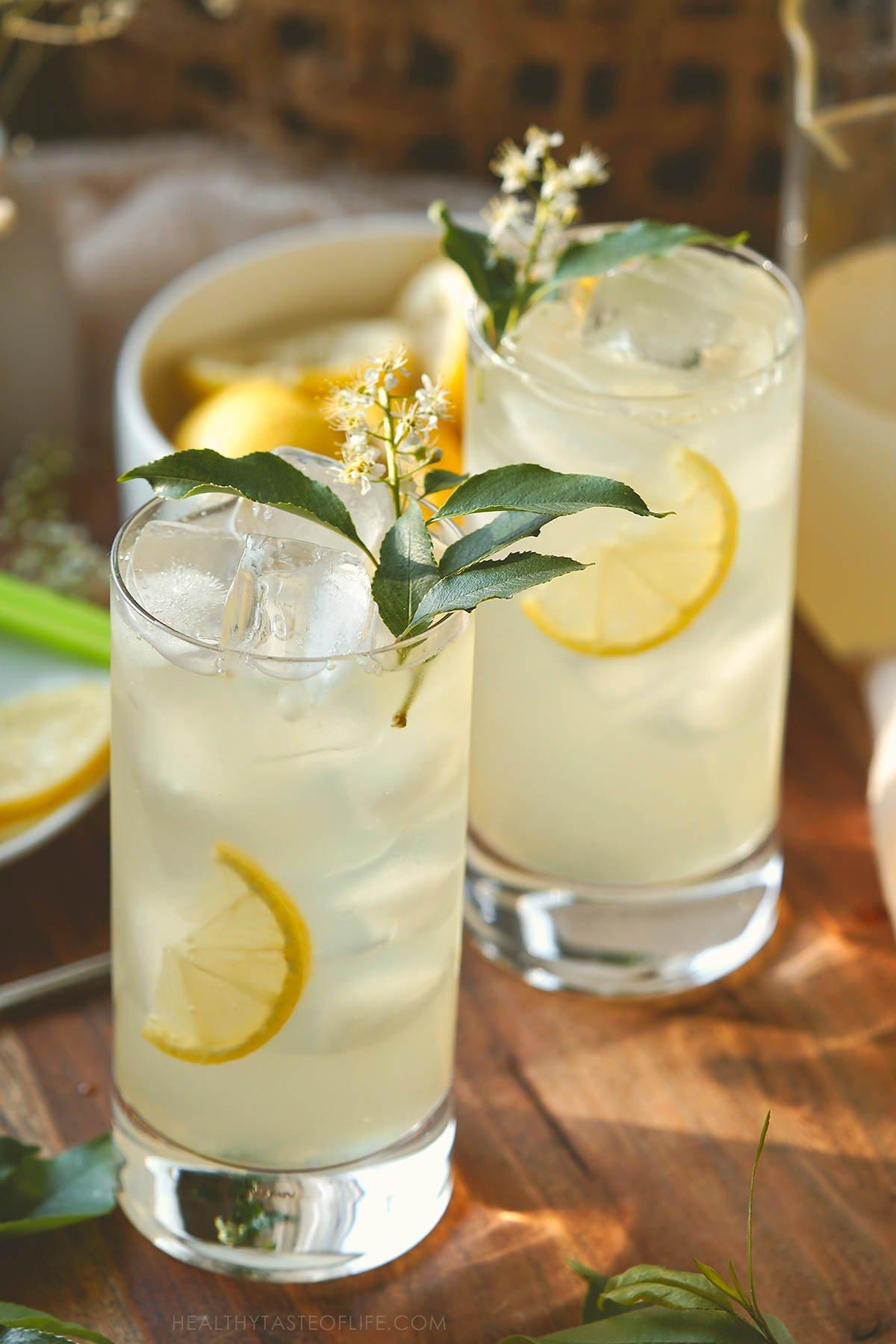 glasses of lemonade with ice and elderflower garnish
