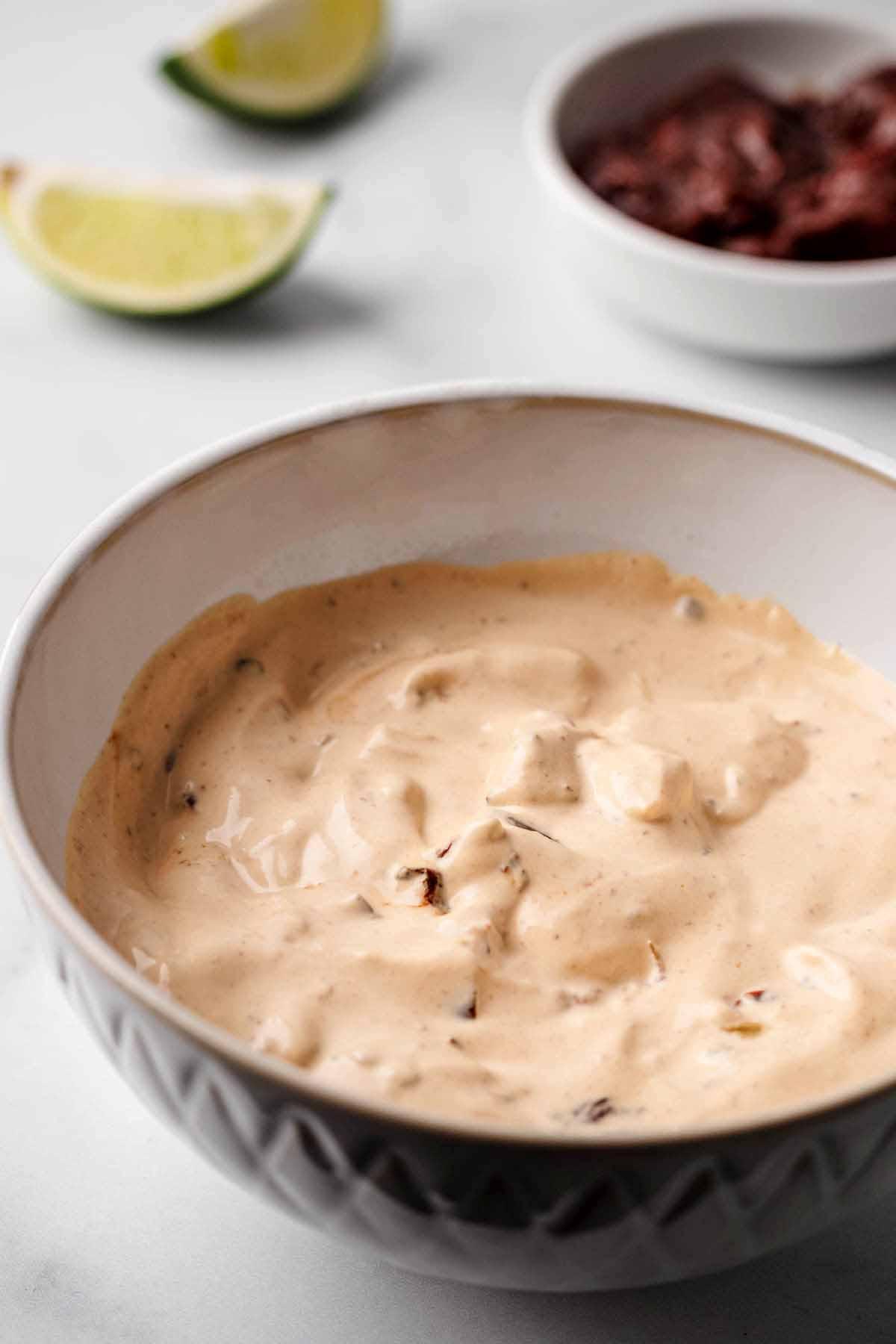 Close up of chipotle mayo being drizzled over köttbullar