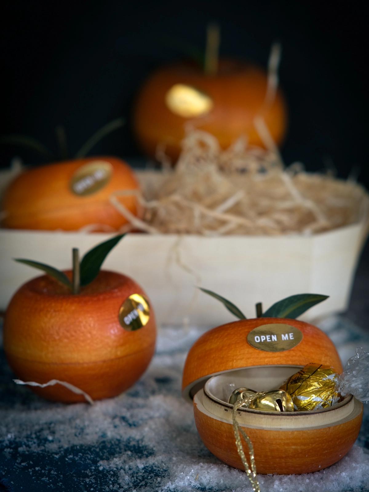 A rustic wooden table set with a bowl of fresh clementines and a glass bowl of the clementine honey dressing