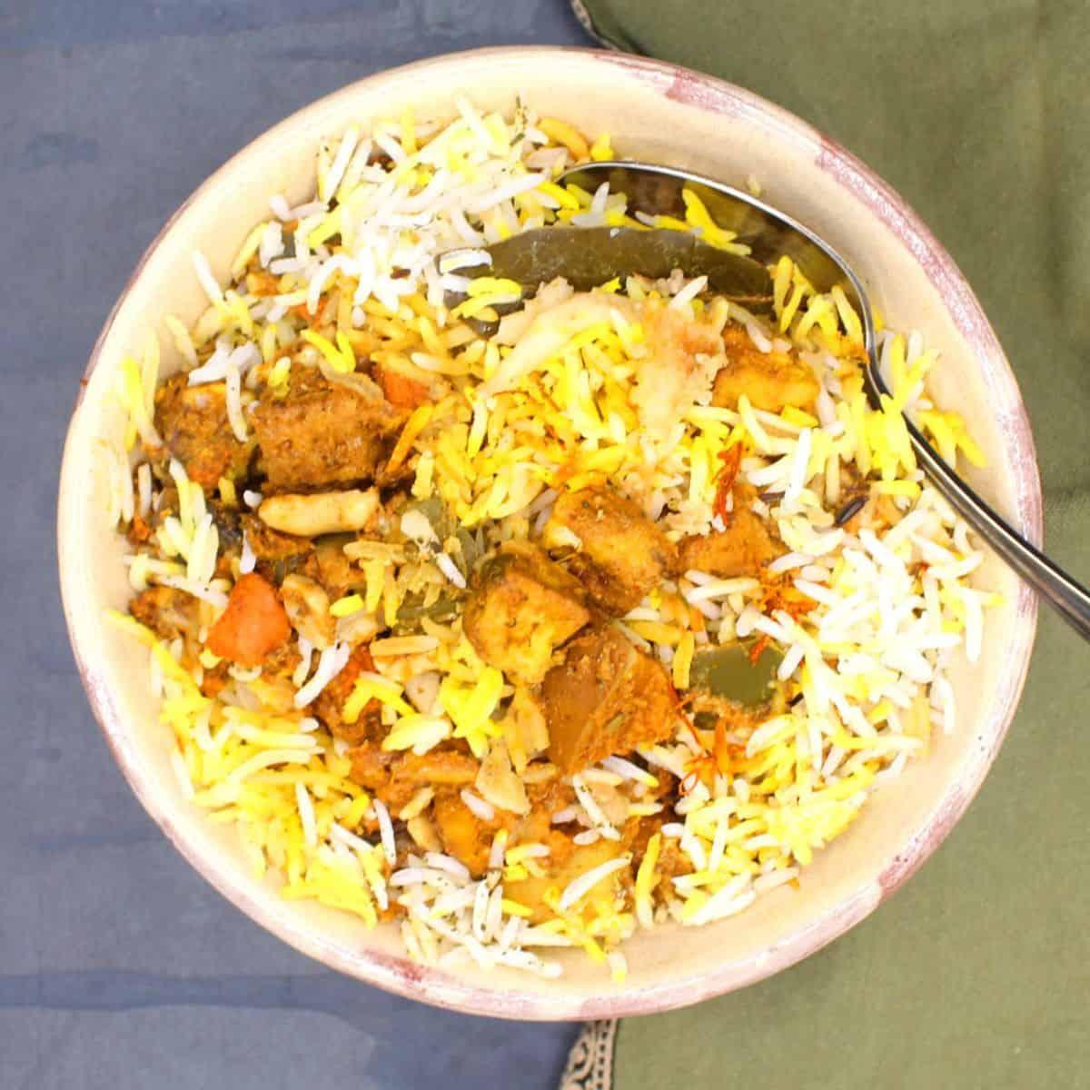 A person enjoying a bowl of Green Bean & Potato Biryani in a cozy setting.