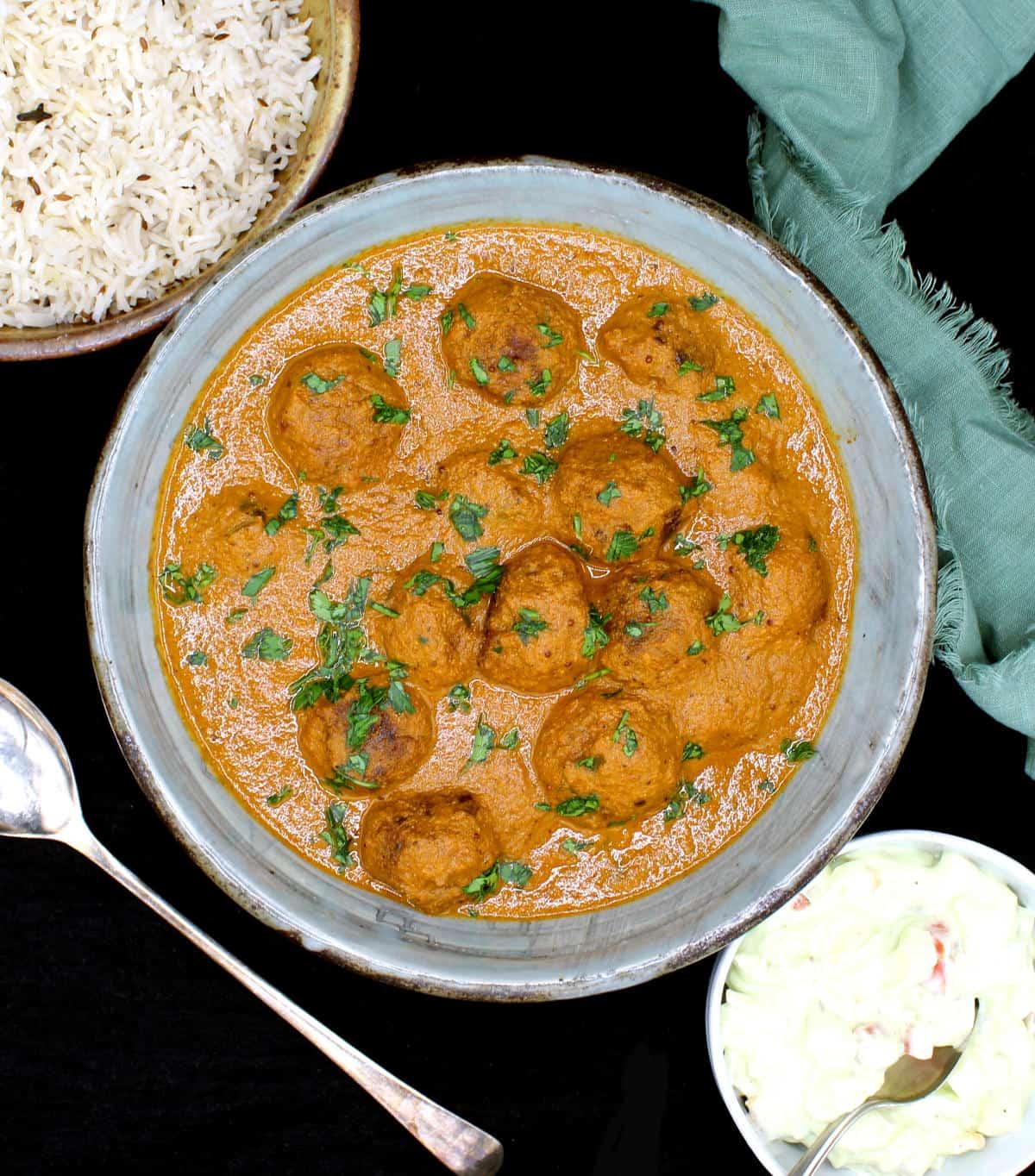 overhead shot of curried coconut plant-based meatballs with rice, garnished with cilantro
