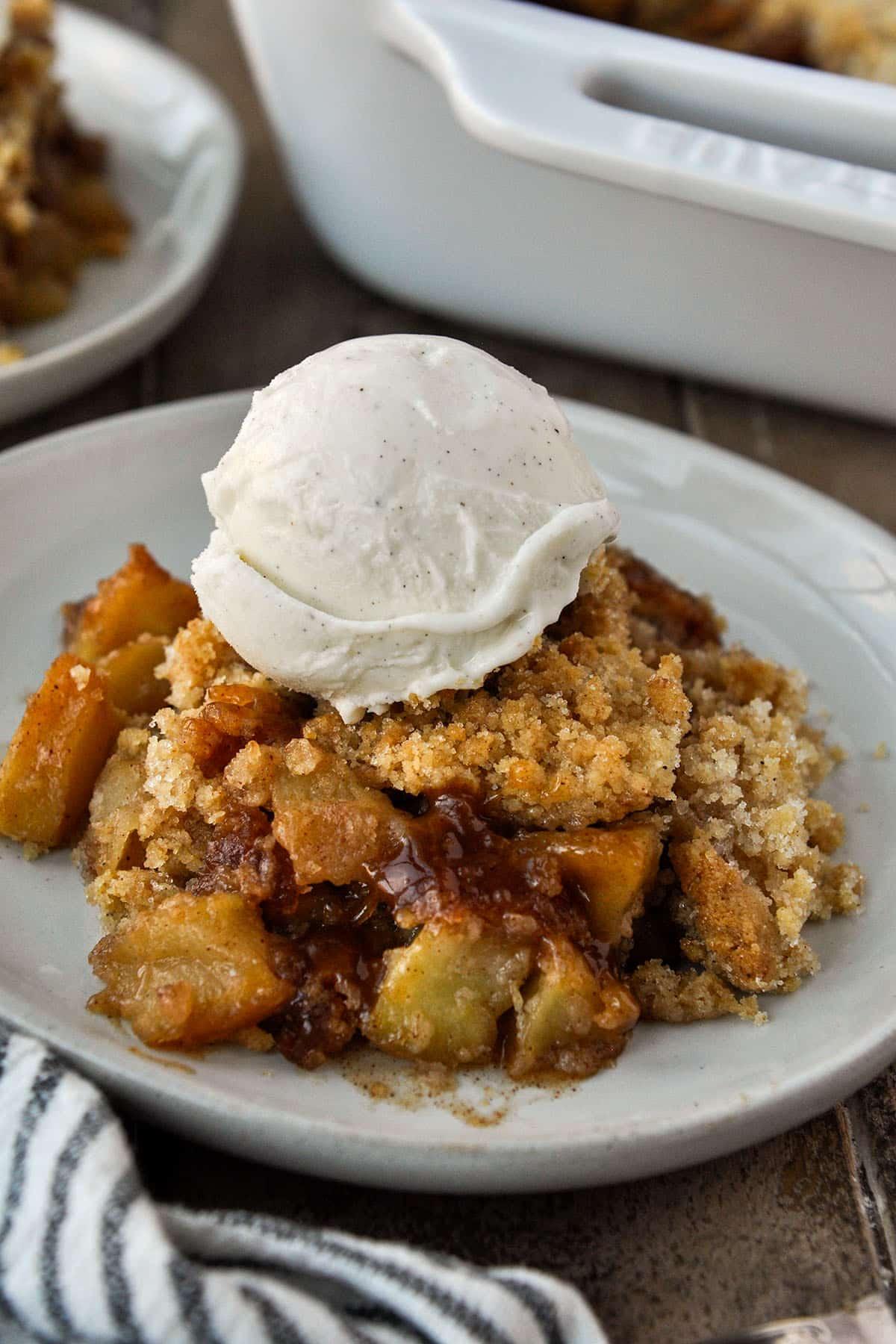 Close up shot of layered apple crisp and vanilla bean ice cream in a glass