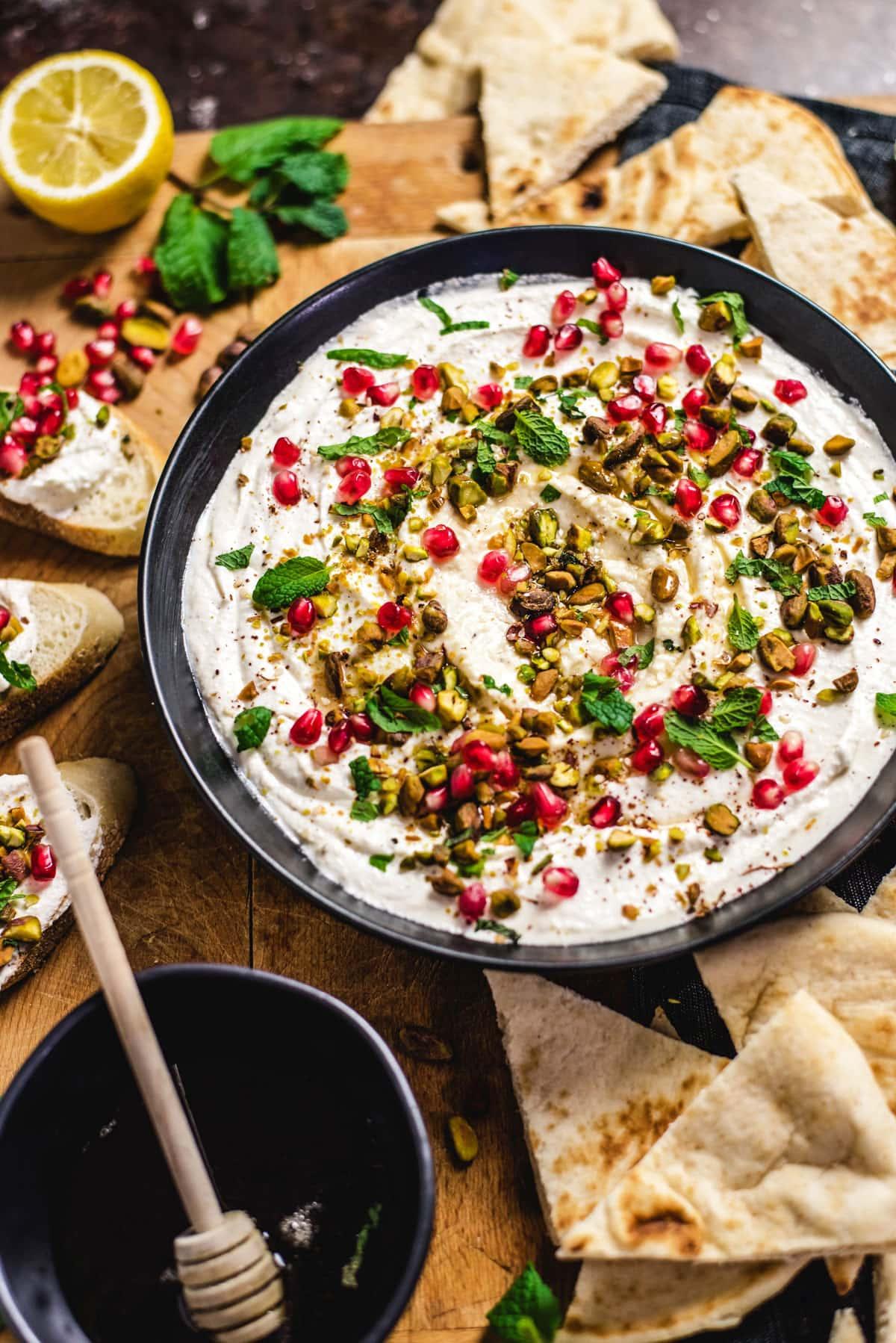 Close-up shot of creamy feta dip with honey drizzle and walnuts, served with pita bread