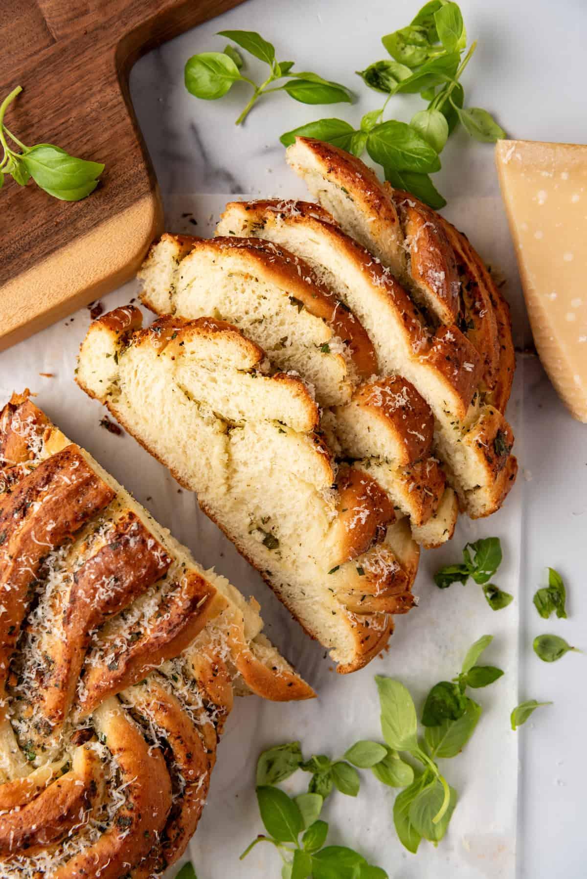 A rustic 9x13 inch baking dish filled with golden-brown garlic herb bagel bread pudding, garnished with fresh herbs.