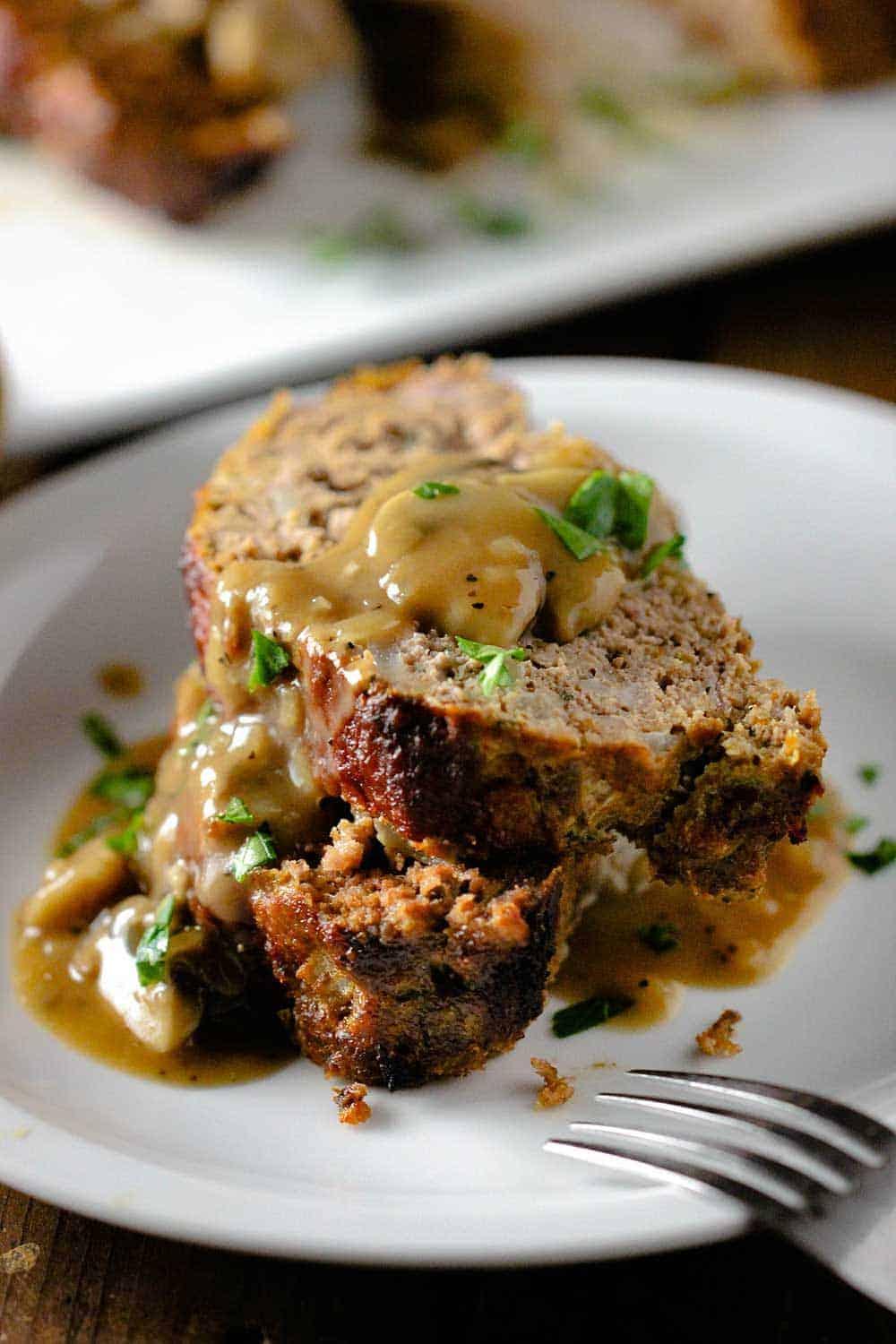 Close-up of a delicious lobster meatloaf with rich mushroom gravy, garnished with fresh parsley