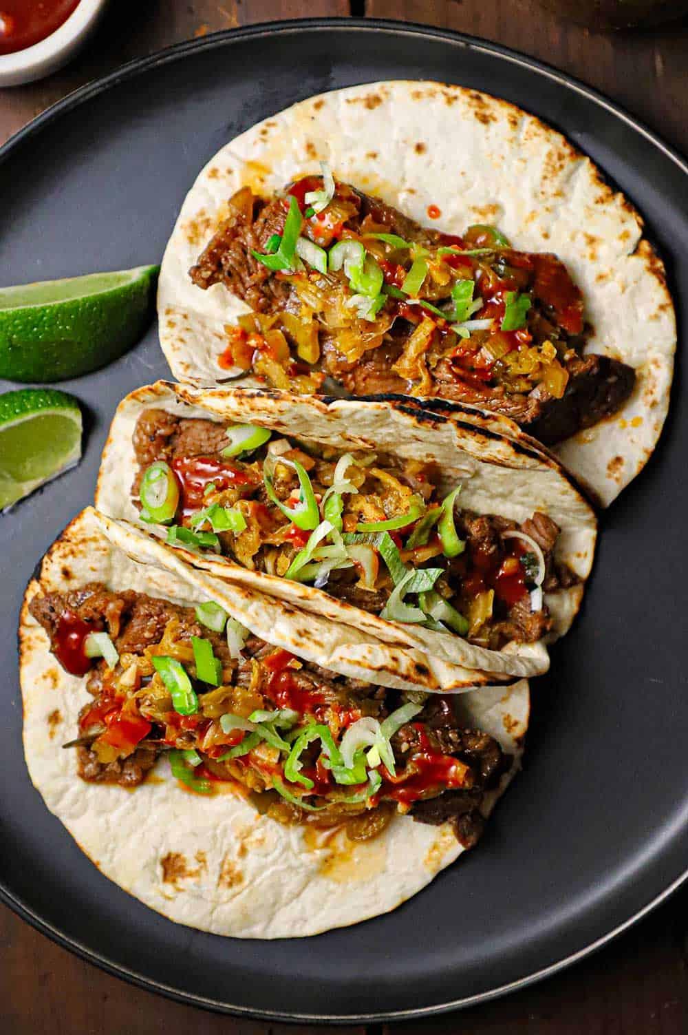 Person assembling kimchi dumplings tacos.