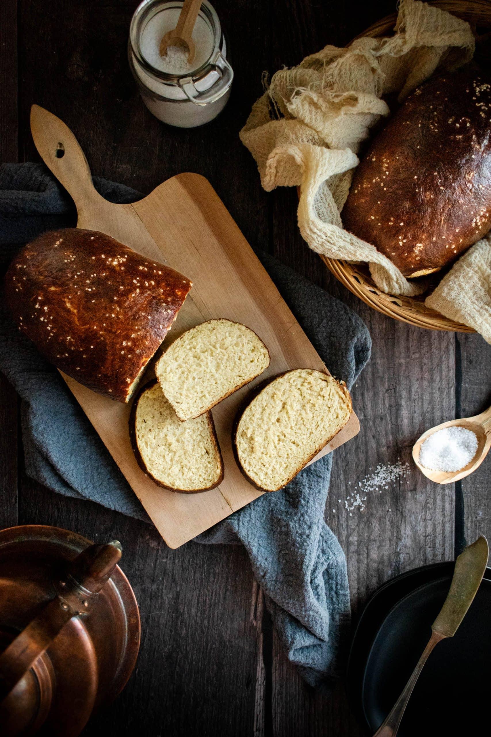 Close-up shot of a rustic sourdough loaf sprinkled with pretzel salt on a wooden table