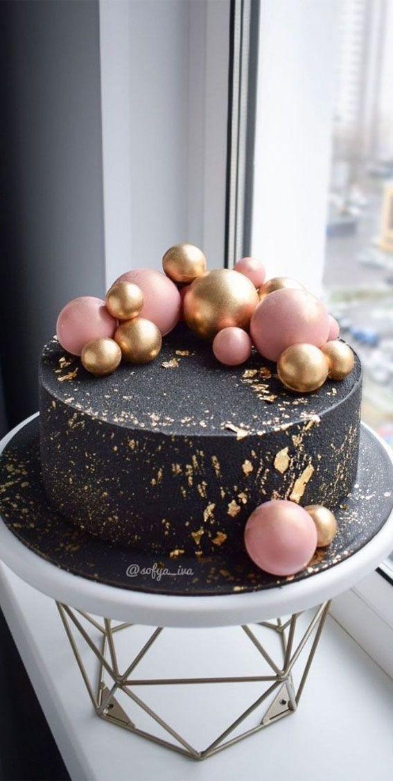 person decorating a dark and elegant birthday cake