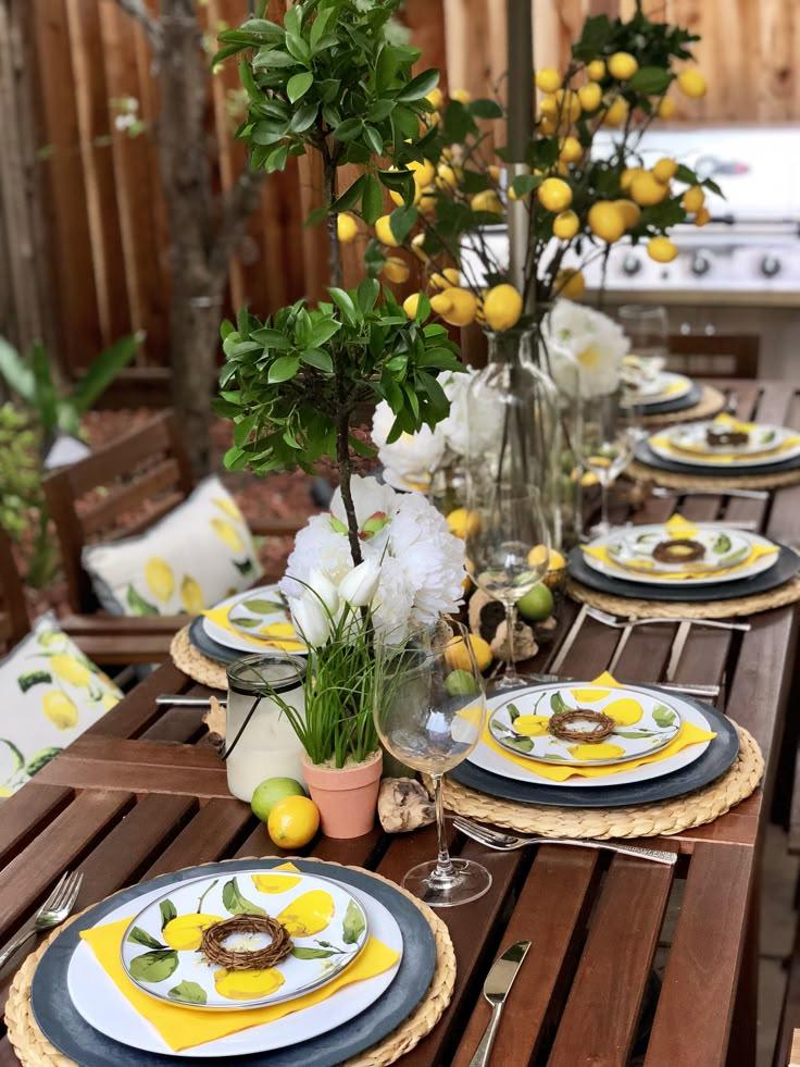 A rustic wooden table set with a plate of Cucumber & Dill Smørrebrød with Lemon, a glass of lemonade, and fresh flowers