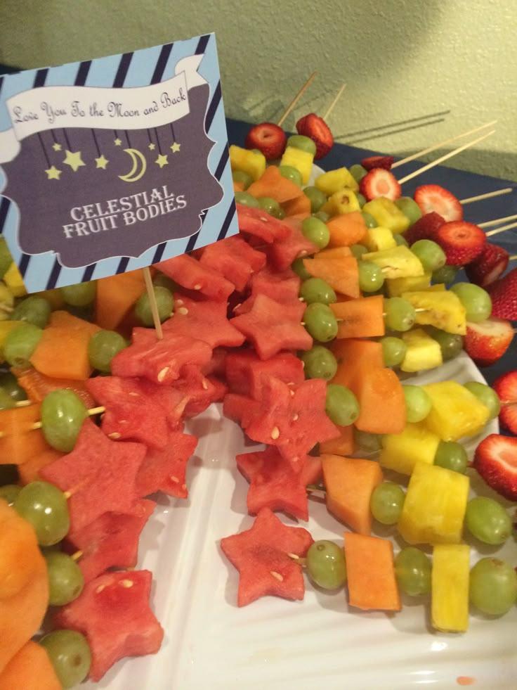 Colorful fruit kebabs arranged in a galaxy-themed pattern