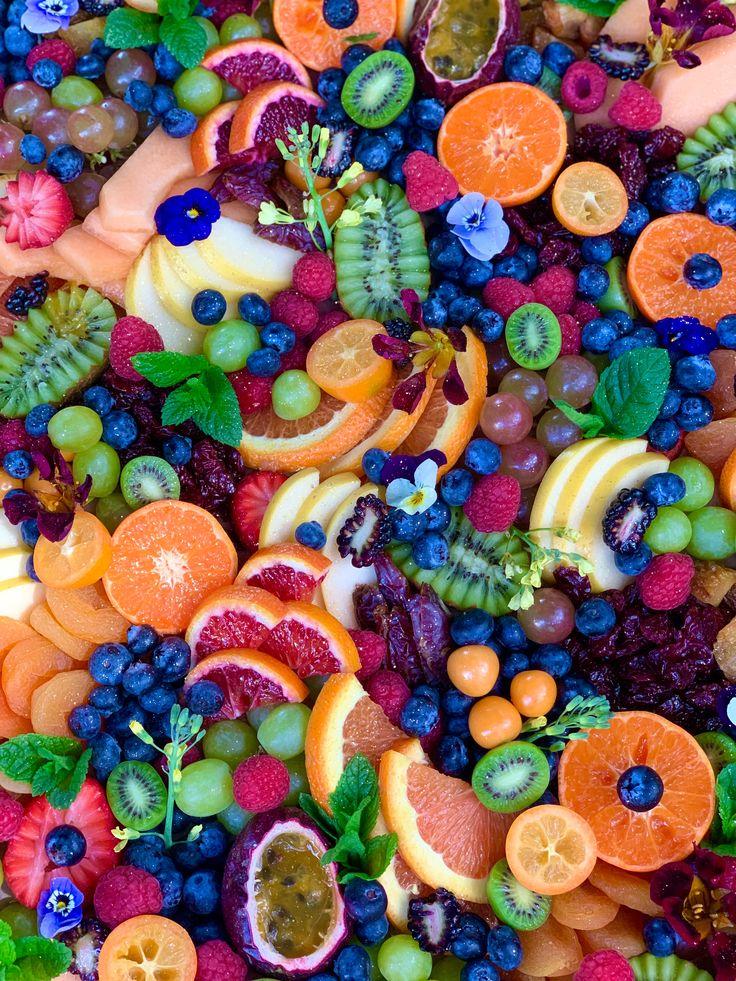 A vibrant and colorful fruit platter featuring glistening cherries arranged artistically alongside other seasonal fruits