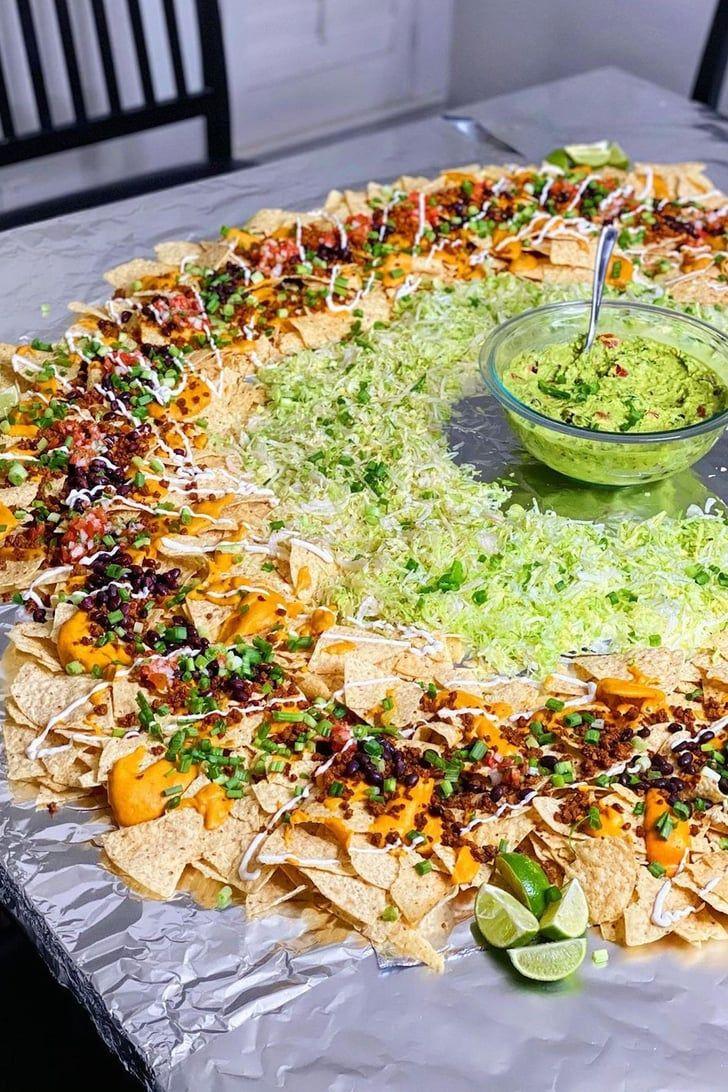 A wide shot of a table set for a party, with a large platter of nachos as the centerpiece