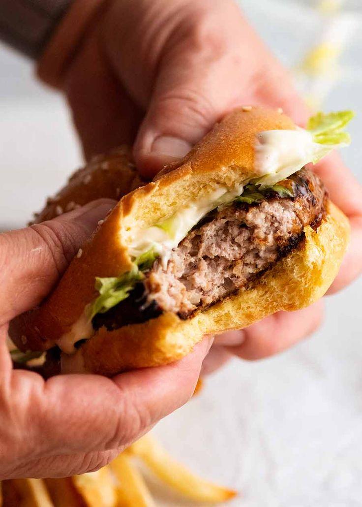 Close-up shot of a person taking a bite of a Hawaiian teriyaki slider
