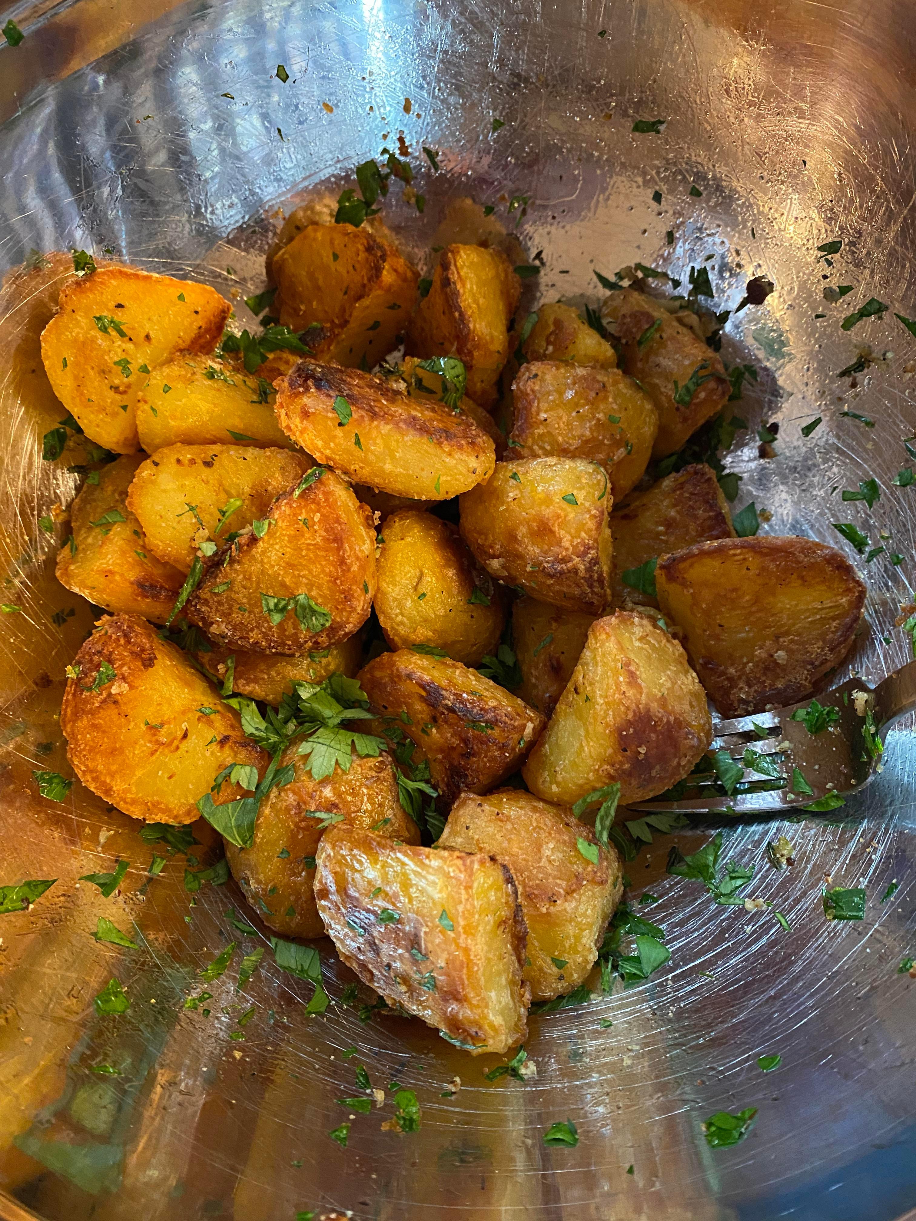 A close-up shot of a single, perfectly roasted potato with spices visible