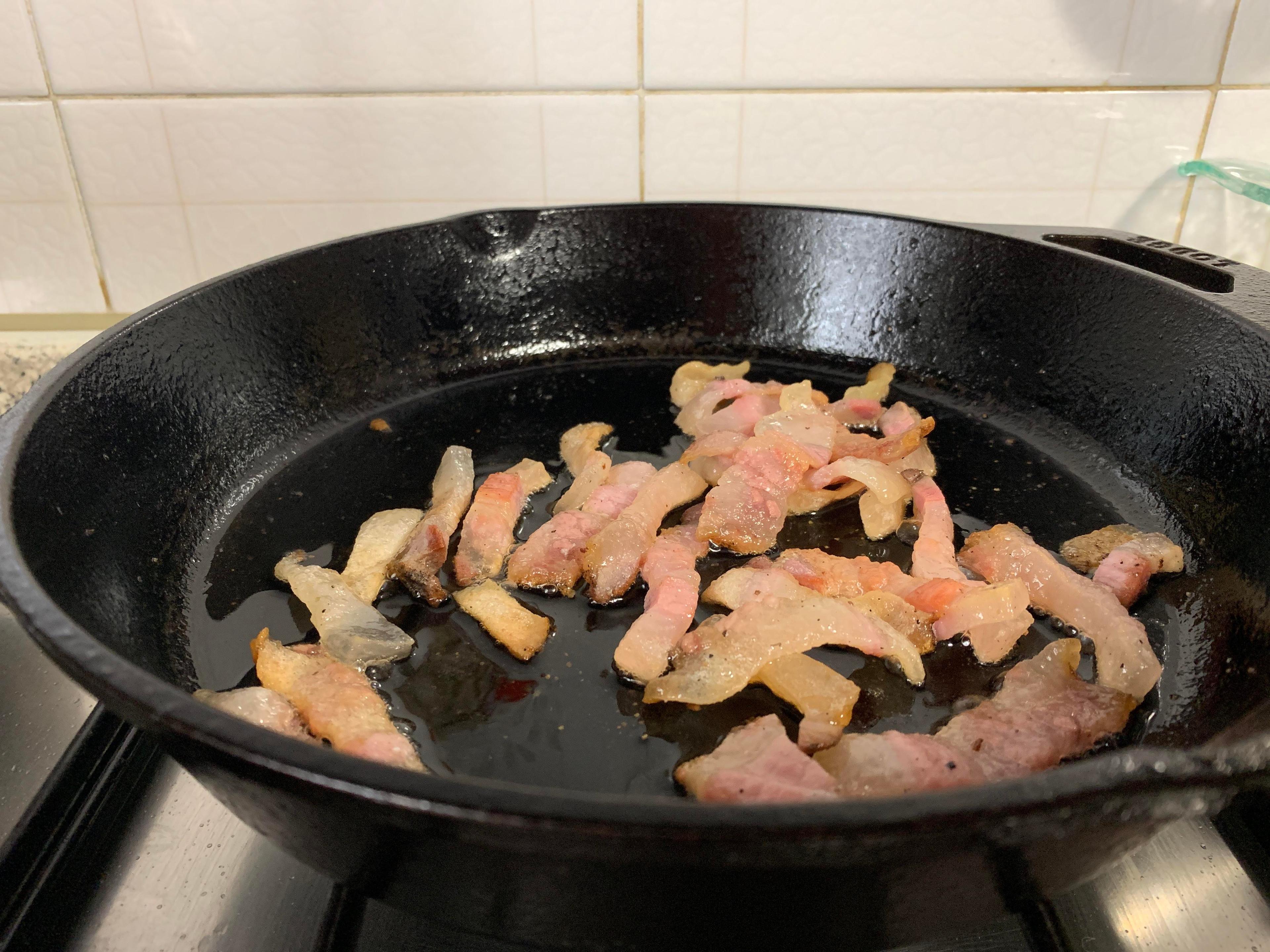 close up shot of guanciale being rendered in a pan