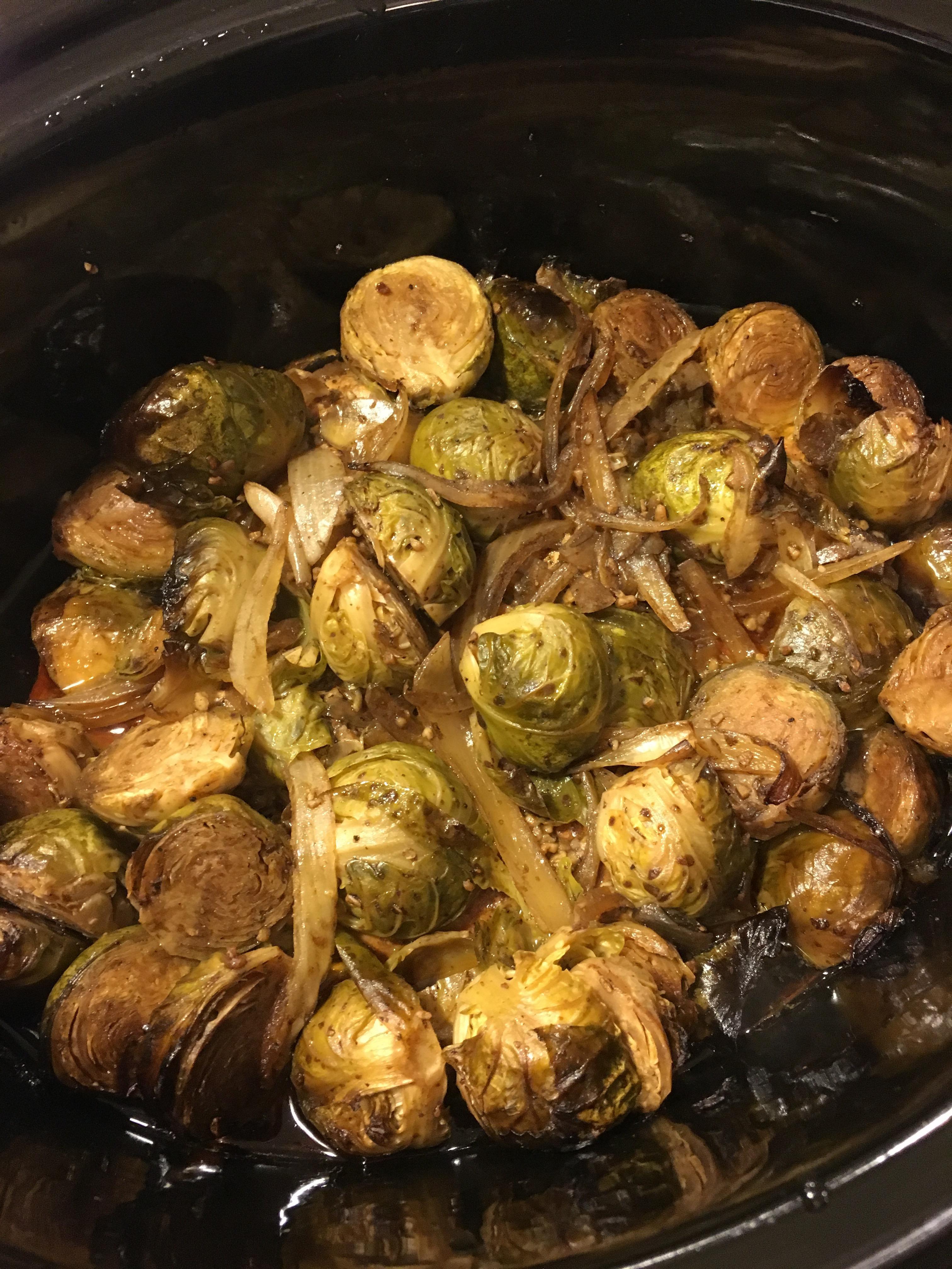 A close-up shot of the slow cooker with the chicken and Brussels sprouts cooking