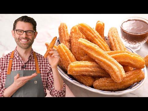 Golden brown hazelnut chocolate churros dusted with powdered sugar, arranged on a wire rack