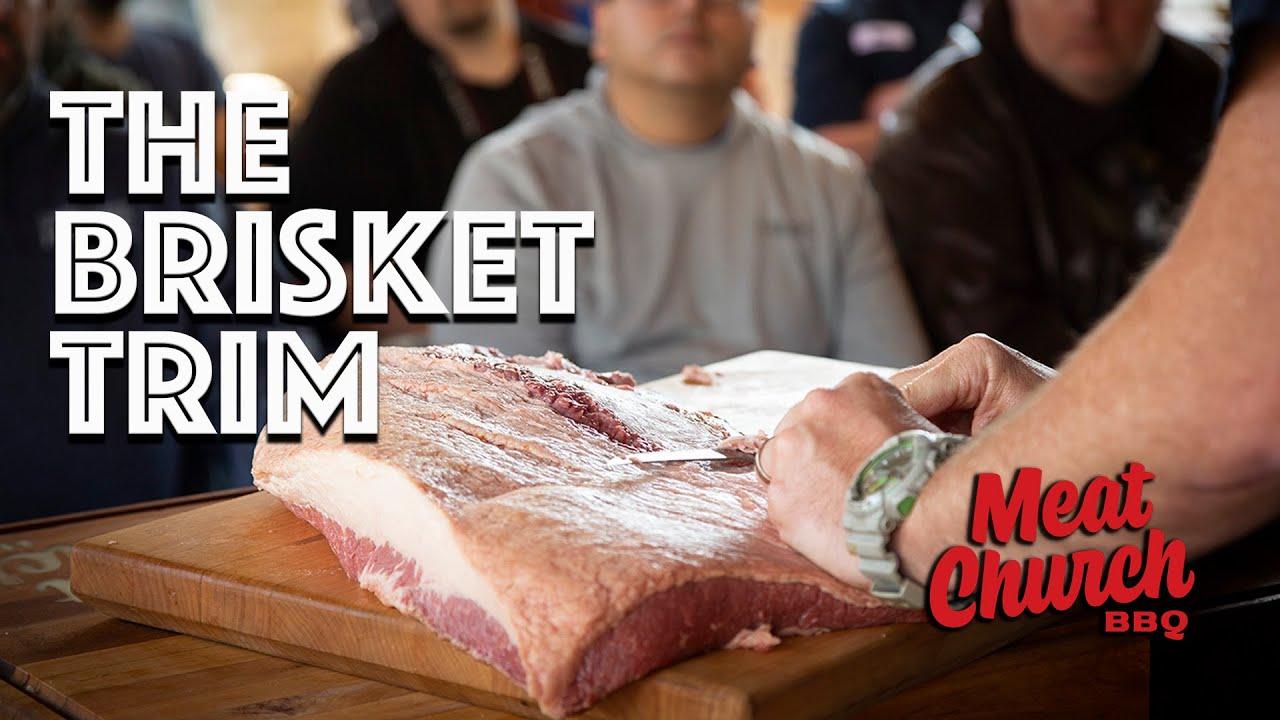 A person expertly trimming a brisket