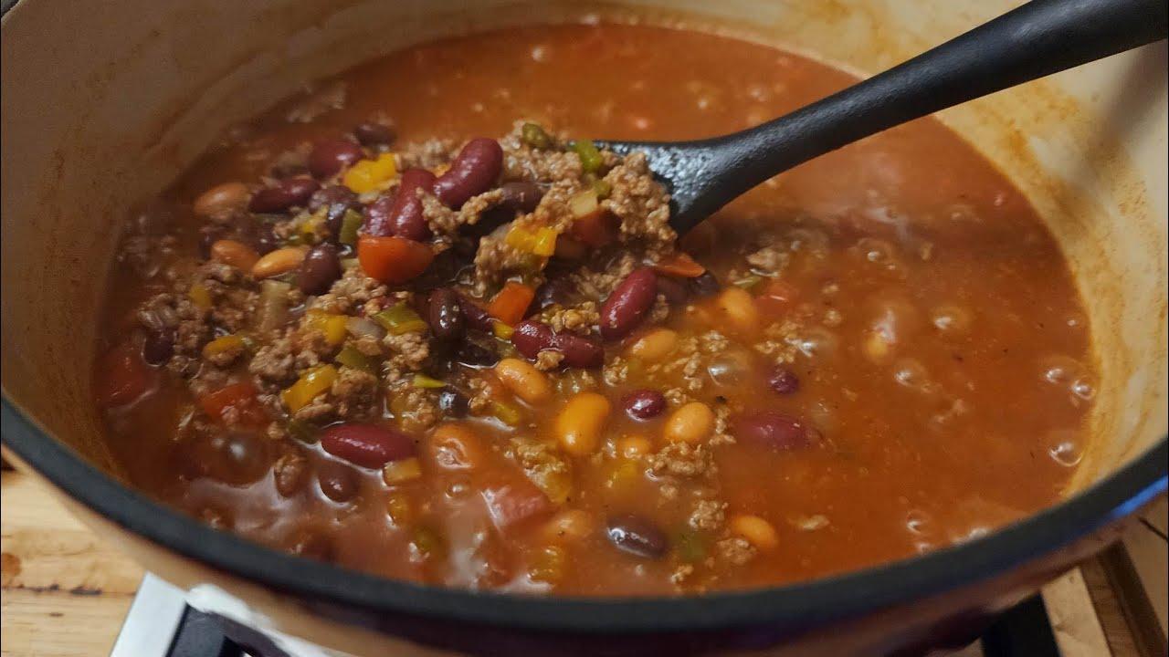 A rustic kitchen scene with a pot of chili simmering on the stove.