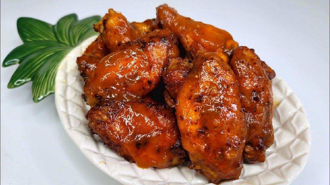 A plate of spicy pineapple habanero wings being shared amongst friends