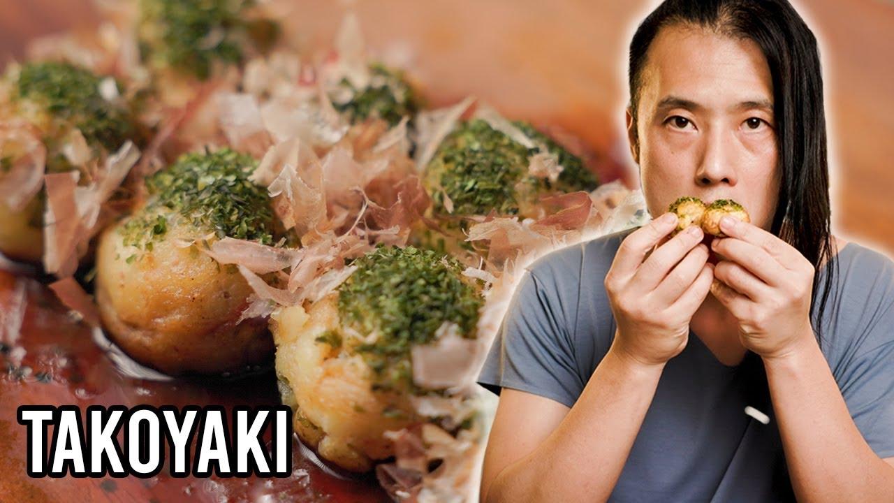 A close-up shot of a person expertly flipping takoyaki balls in a takoyaki pan