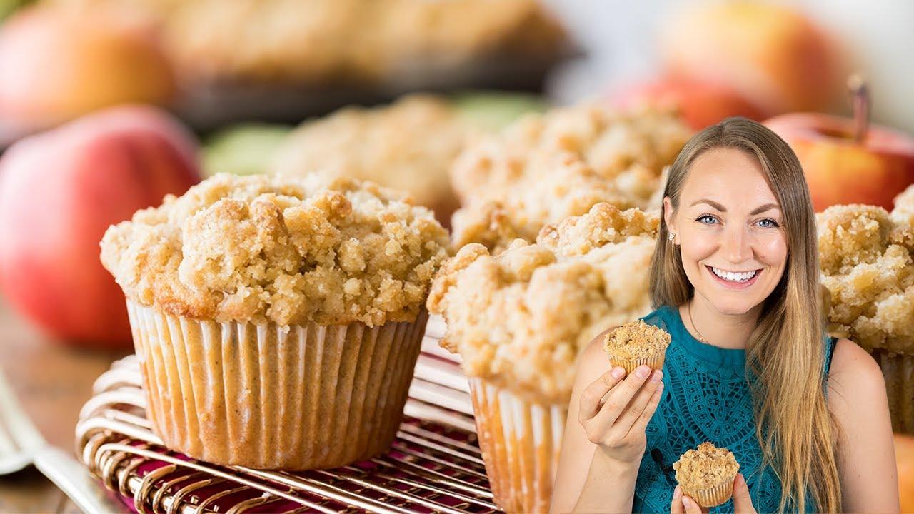 Close-up of a person enjoying an apple crumble muffin, smiling
